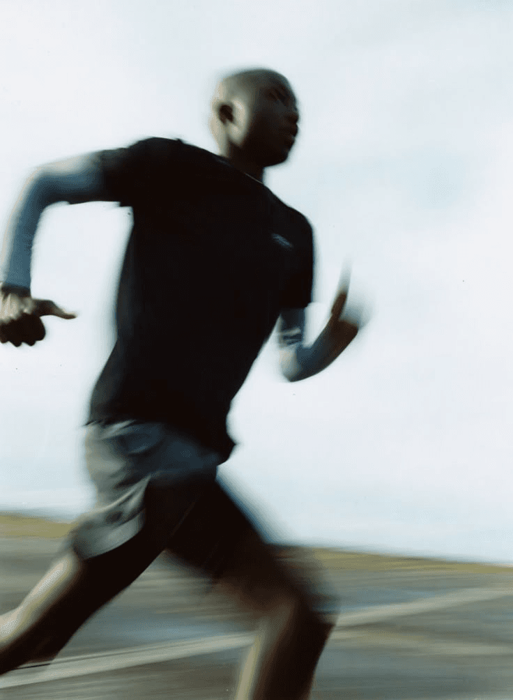 woman jogging on gray road across mountain during daytime