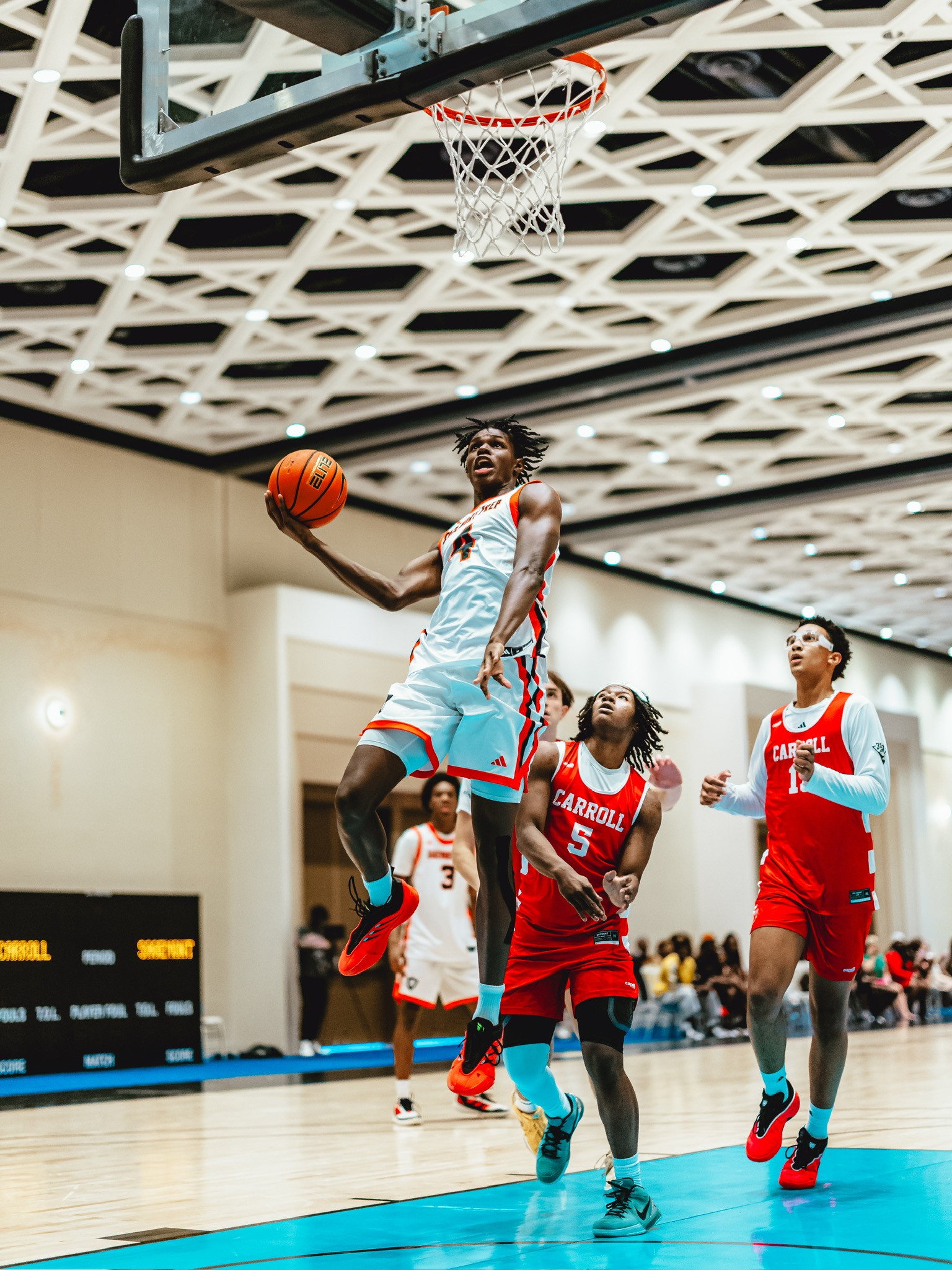 Three people sitting on a couch in a room looking at mobile devices