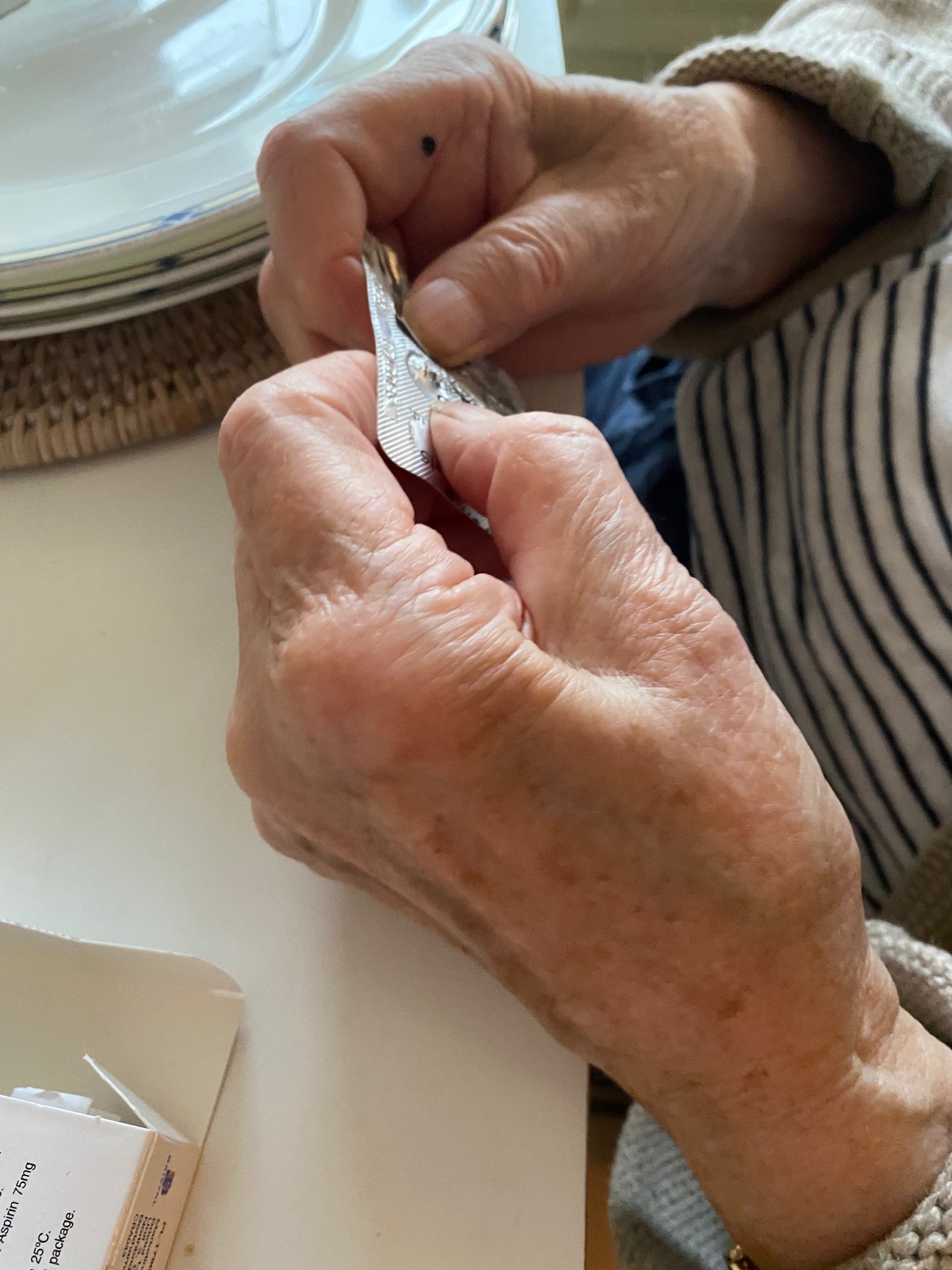 Elderly person opening pill packet 3.