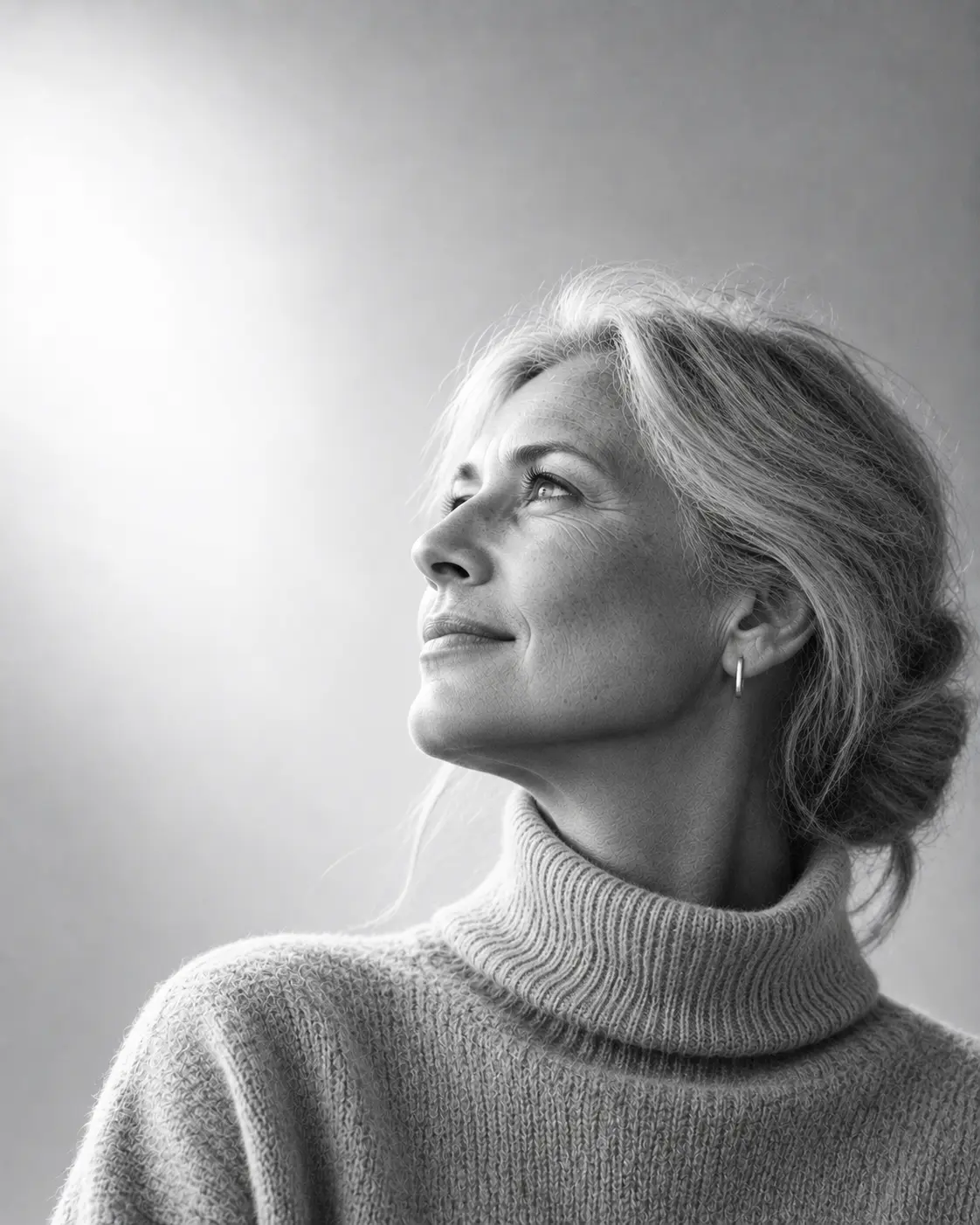 Odile Marchetti, founding partner, in a light grey roll-neck, looking up and to the left against a bright silver wall