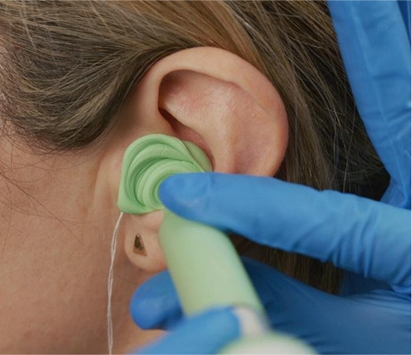A woman having her ear impressions taken.