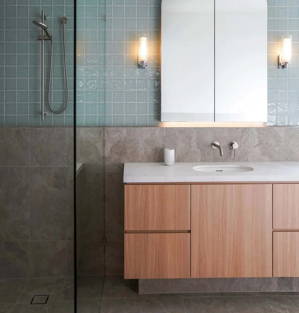 Modern bathroom with wood vanity, sleek fixtures, and glass shower.