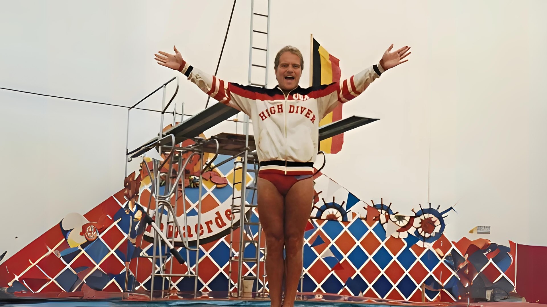 Personne debout sur une structure avec les bras ouverts devant un décor coloré