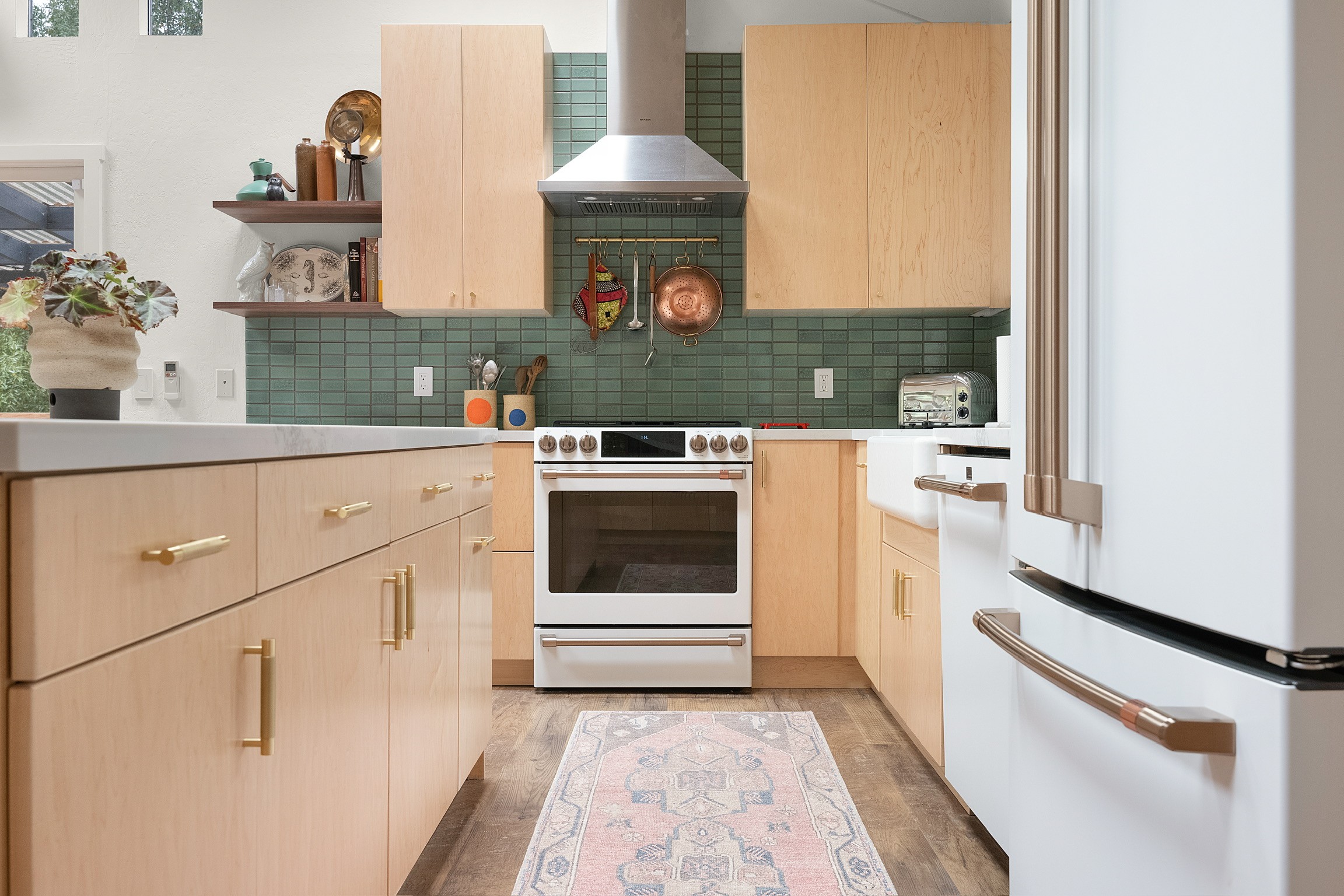“Bright modern kitchen with light wood cabinets, large island, and wood ceiling with skylights”