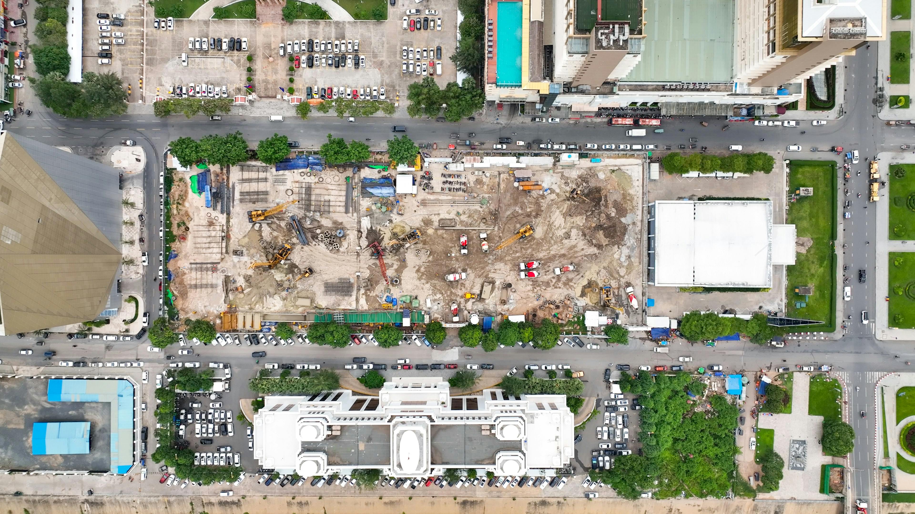 Aerial view of a large-scale urban construction site in Phnom Penh showing excavation, foundation work, and heavy machinery supporting discussion on coordinated building delivery