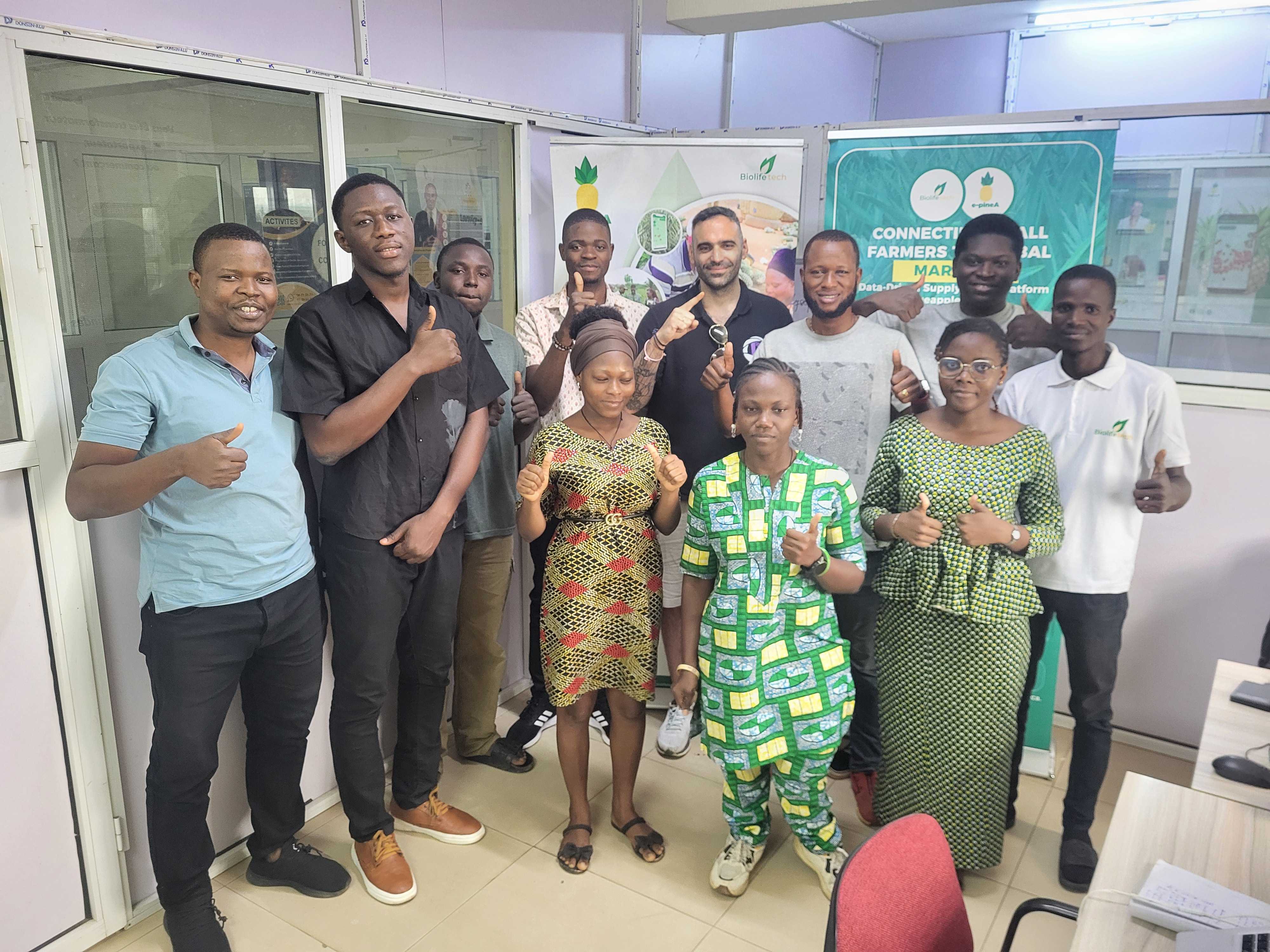 Two people sit across a table in a stylish room with red velvet walls and a large red pendant light. The mood is intimate and modern.