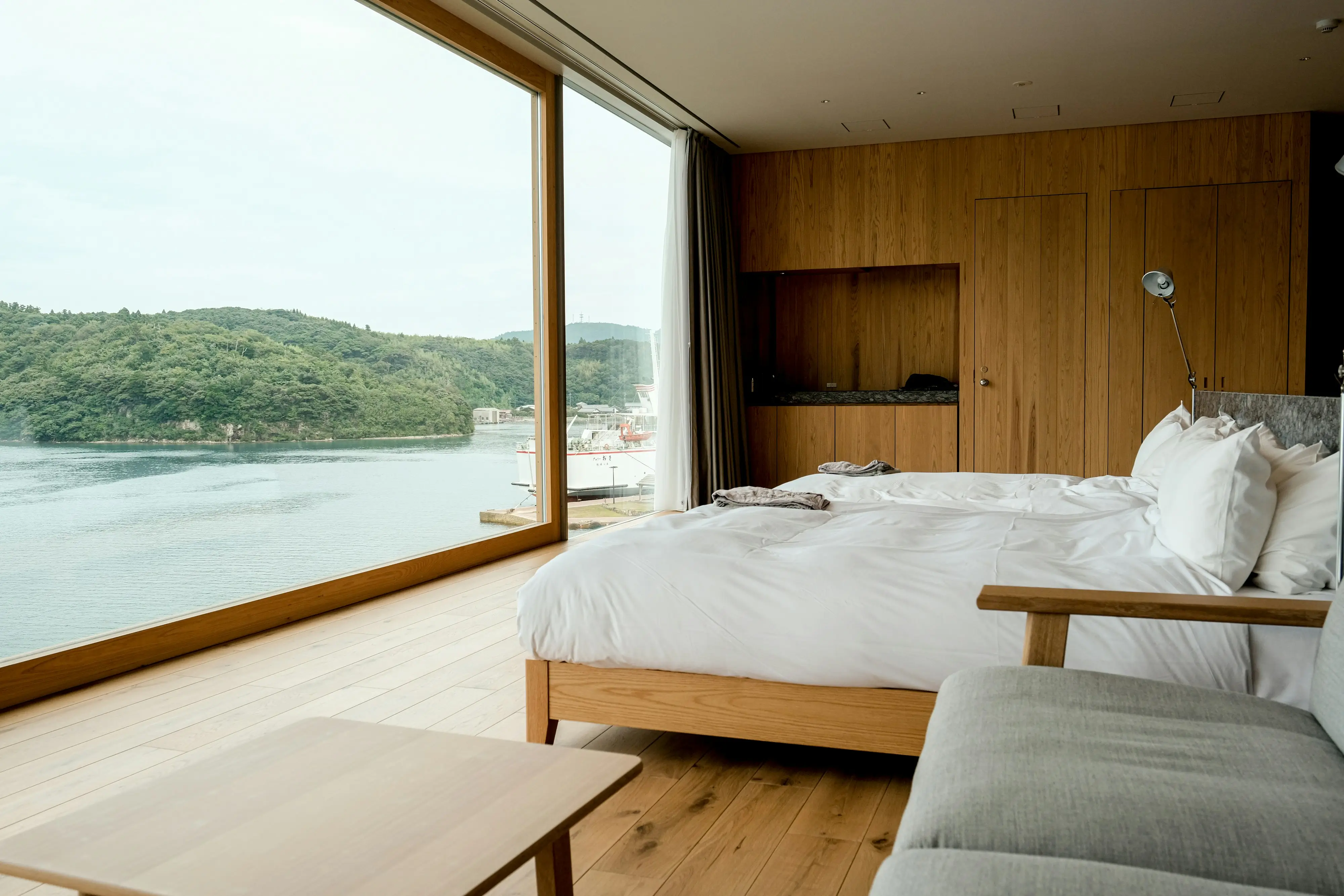 A stylish bedroom with expansive windows showcasing a beautiful water view.