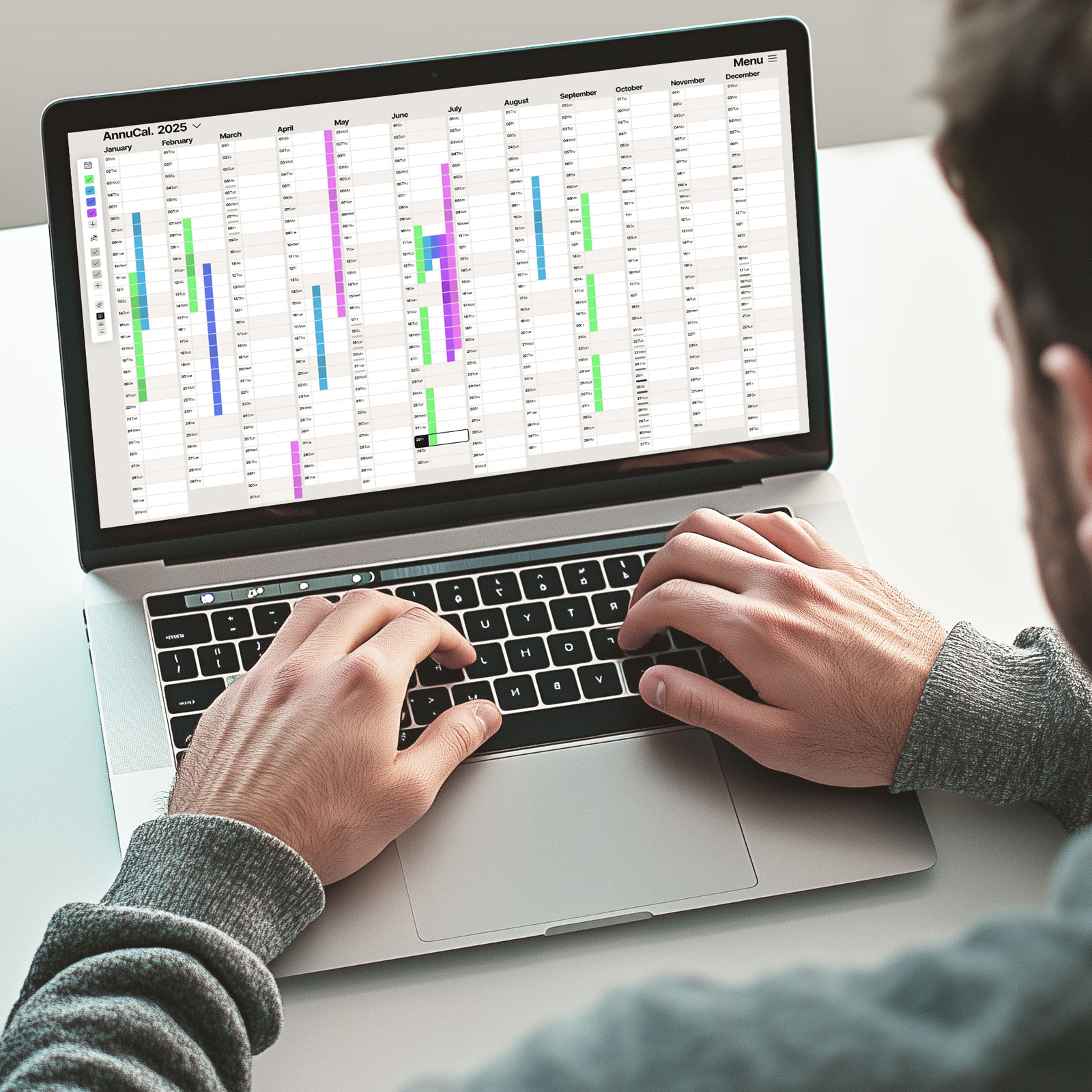 Man in front of Laptióp interacting with Annucals Full Yearly Calendar View