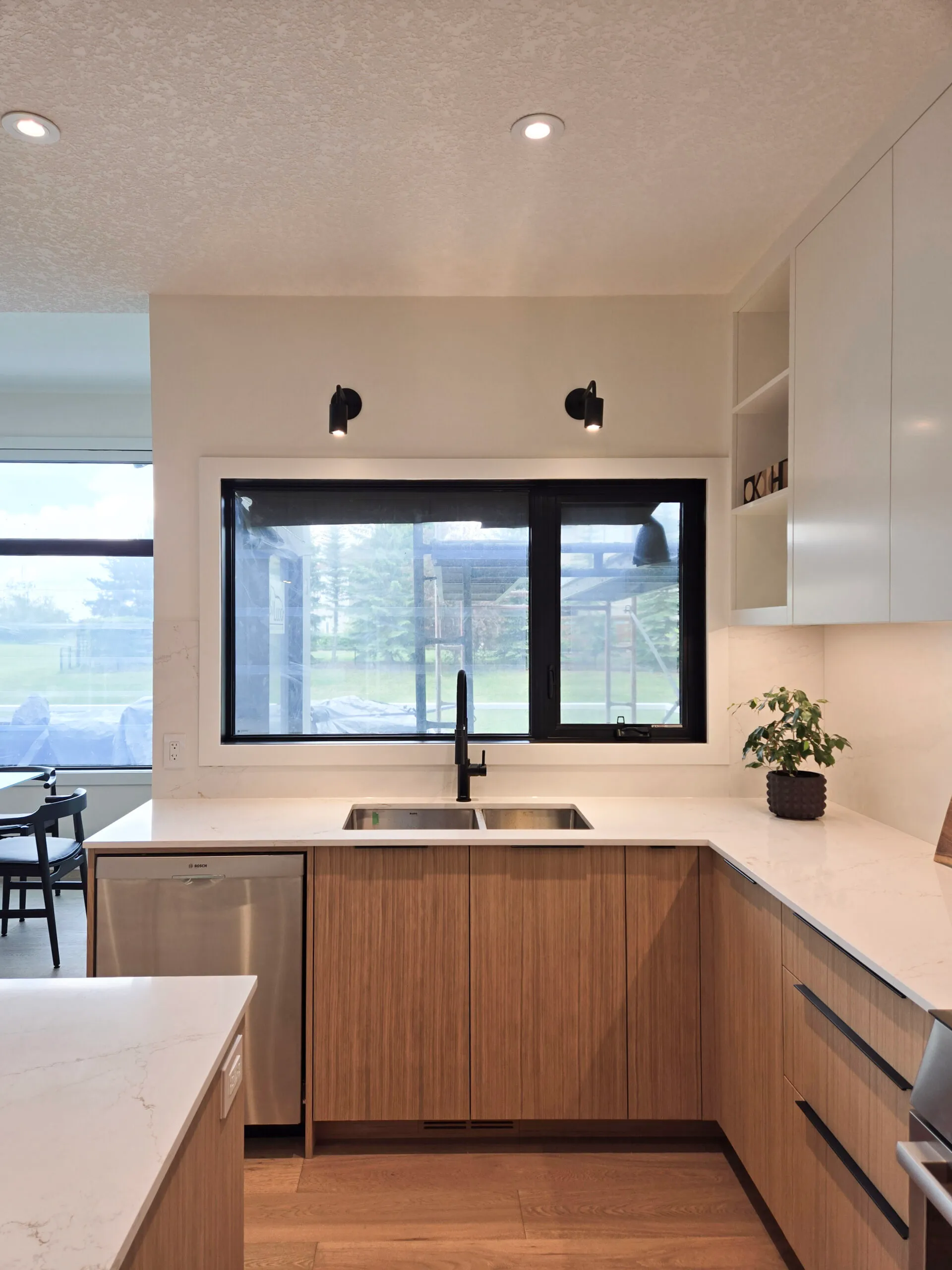 Image of warm kitchen with large window with black casings.