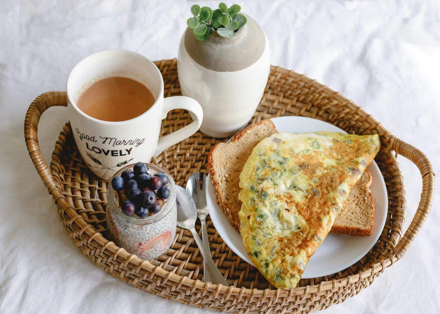 coffee, blueberries, omellette on toast on a breakfast plate