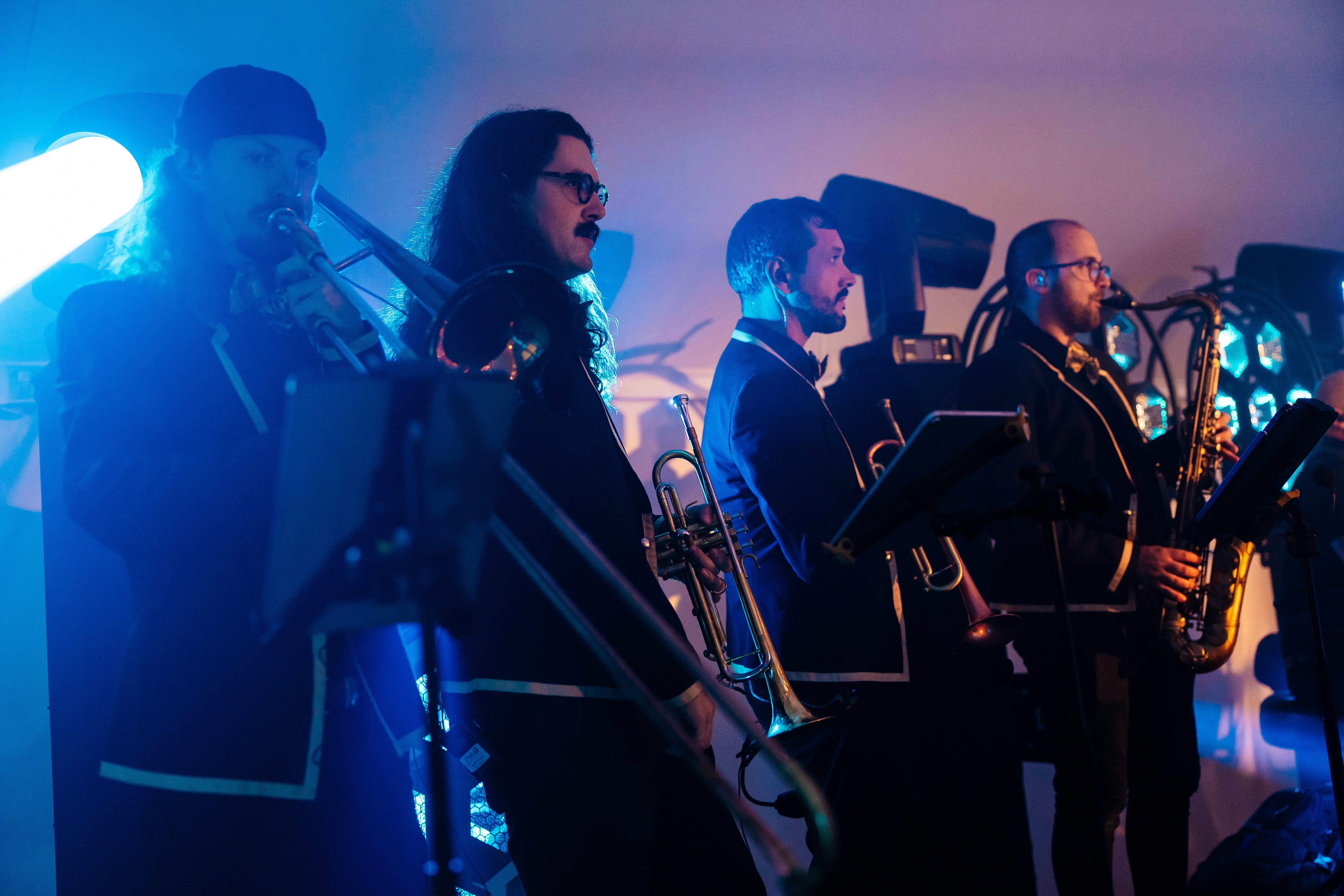 A band plays music on a stage with blue lights.