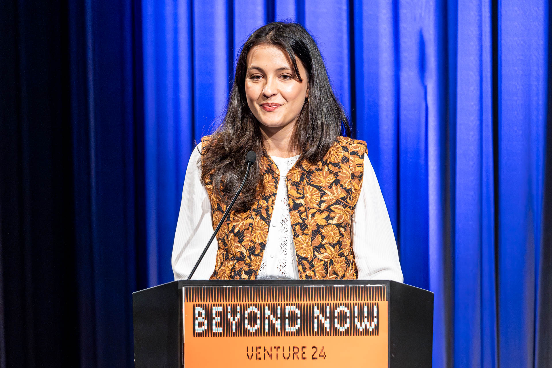 a student at a podium presenting a project in a Theatre