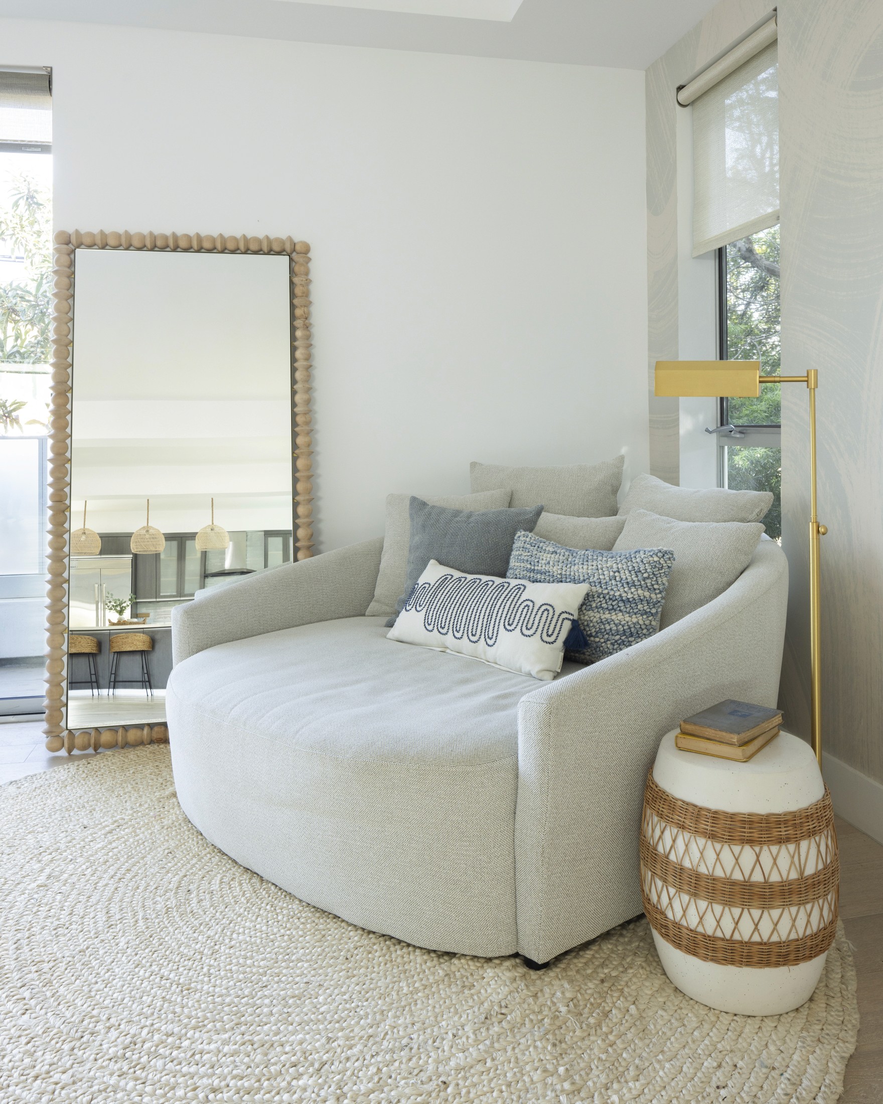 Lounge seating in living room with large accent mirror and woven rug