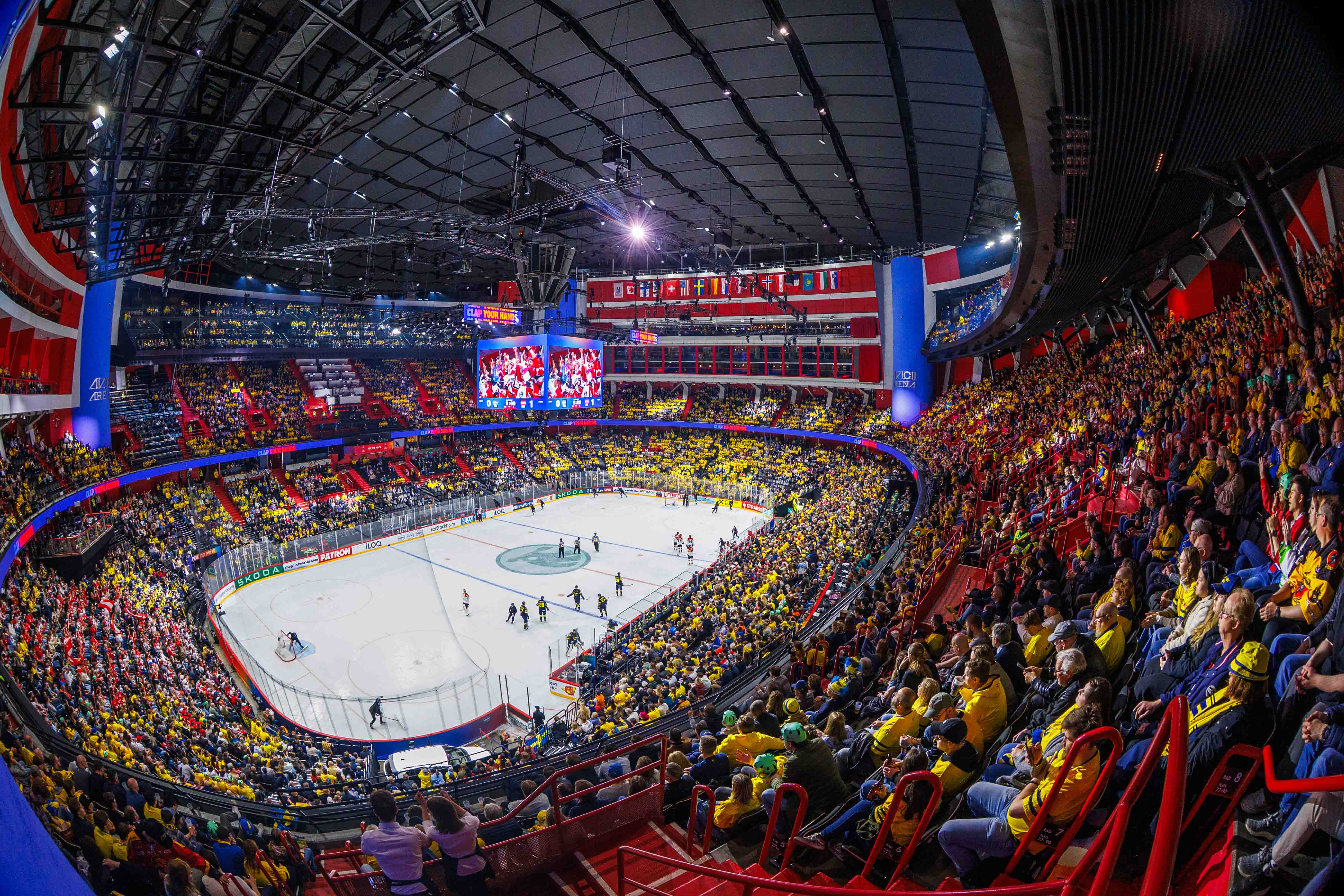 Overhead shot of ice rink inside Avicii Arena as teams practice under a fully rigged lighting and LED system installed by Creative Technology.