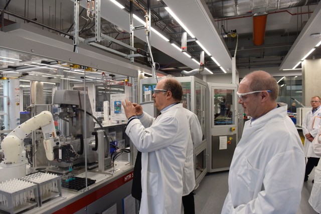 Sir Mark Walport (Centre) views the robotics facility at the Materials Innovation Factory