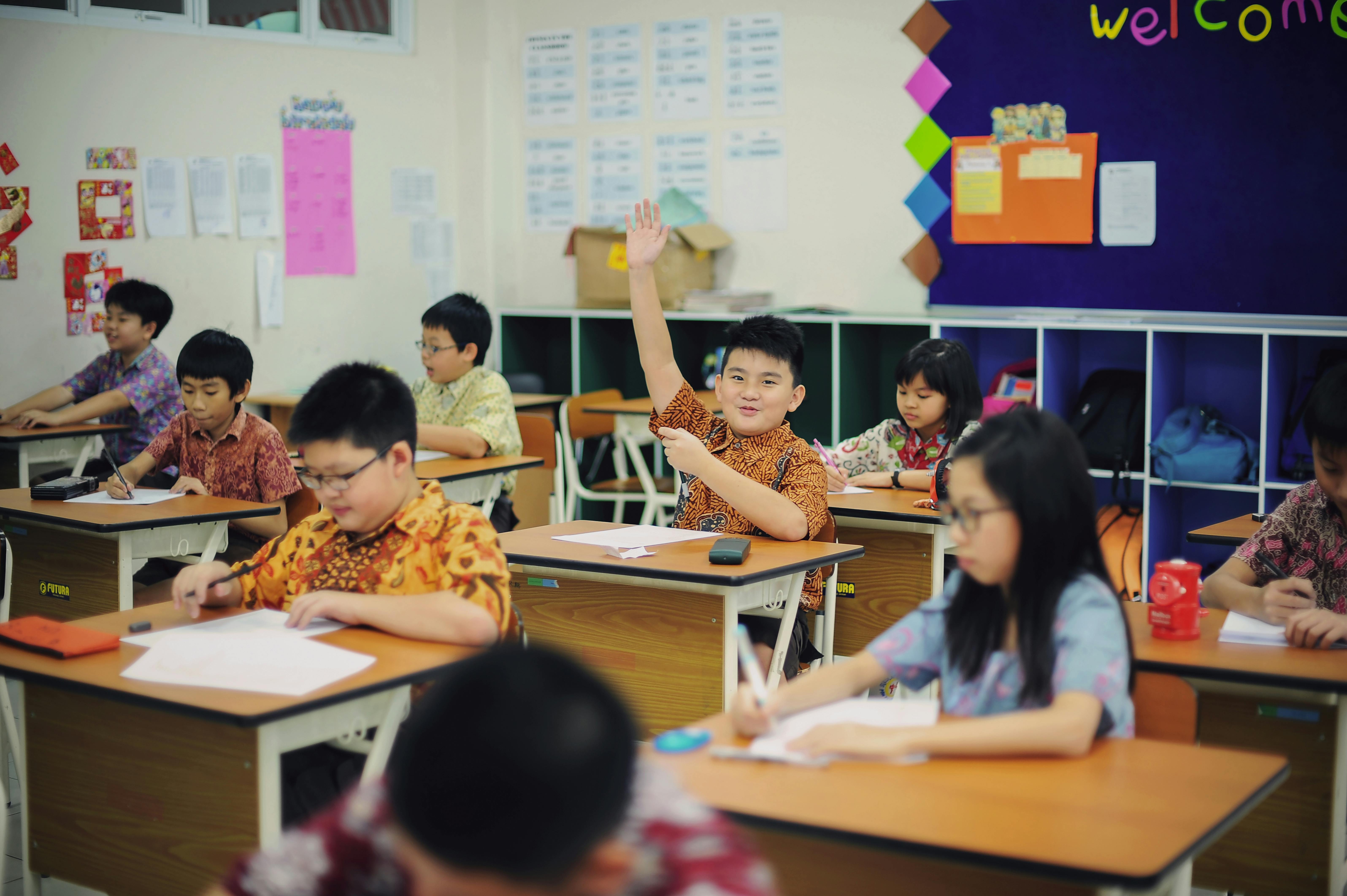 Chinese pupils raising hands politely to wait for teachers to call on them before asking questions