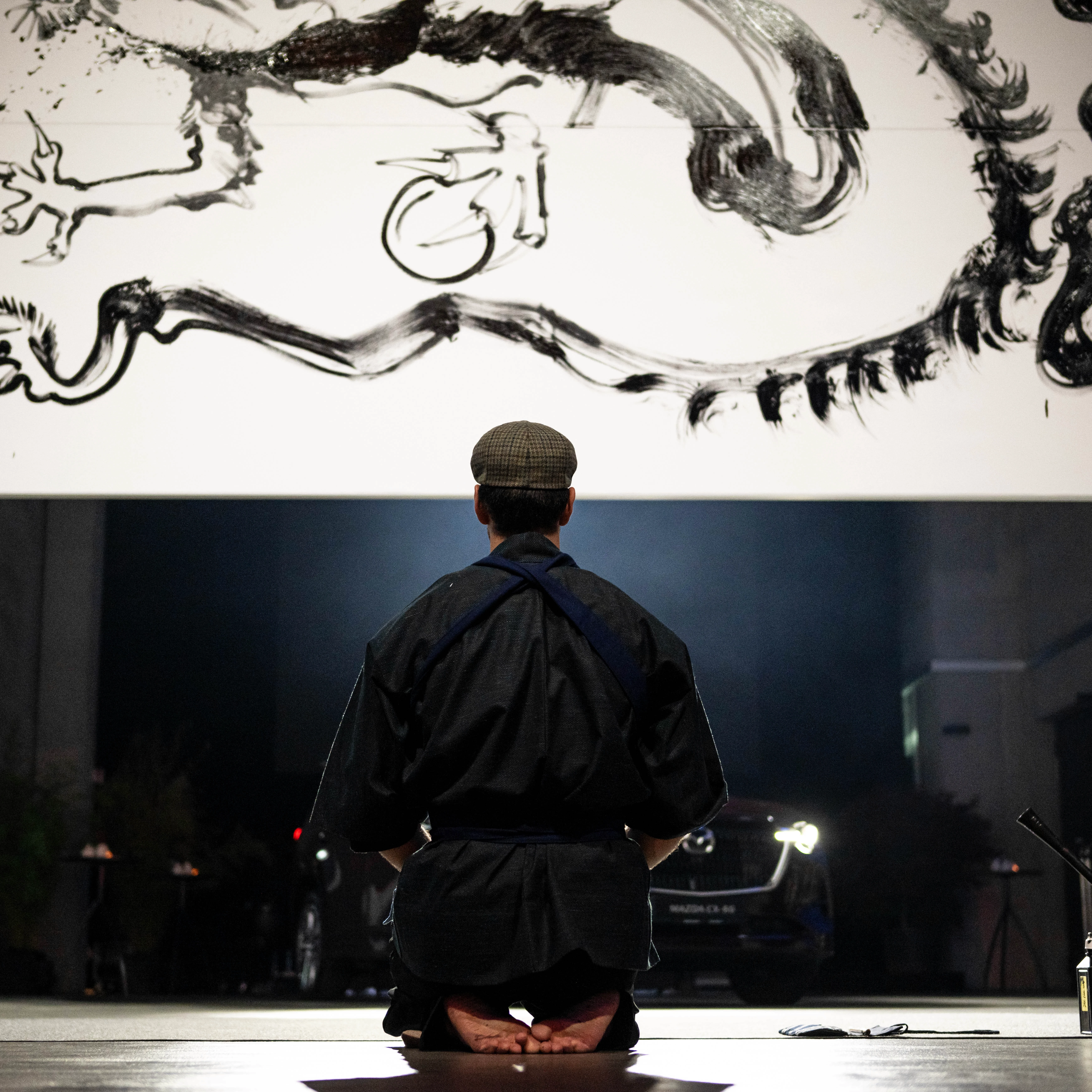 Artist observing the finished artwork at the Mazda CX-80 event
