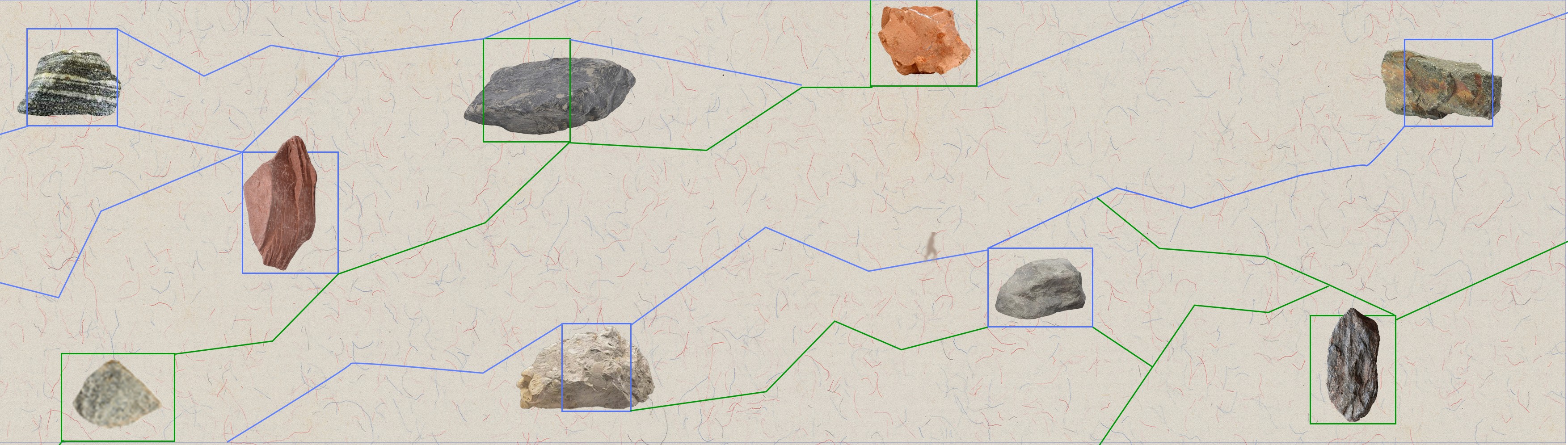 Different types of stones scattered in random patterns on an abstract pattern of lines and rectangles.