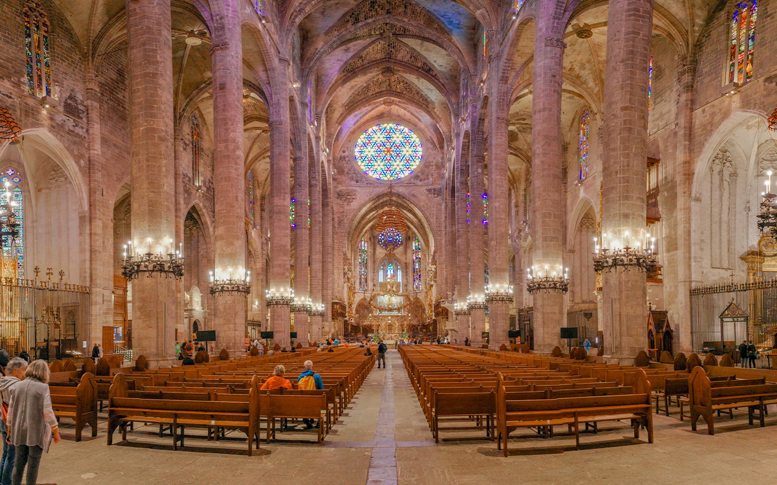 Interior de la Catedral de Palma con vitrales y techos abovedados.