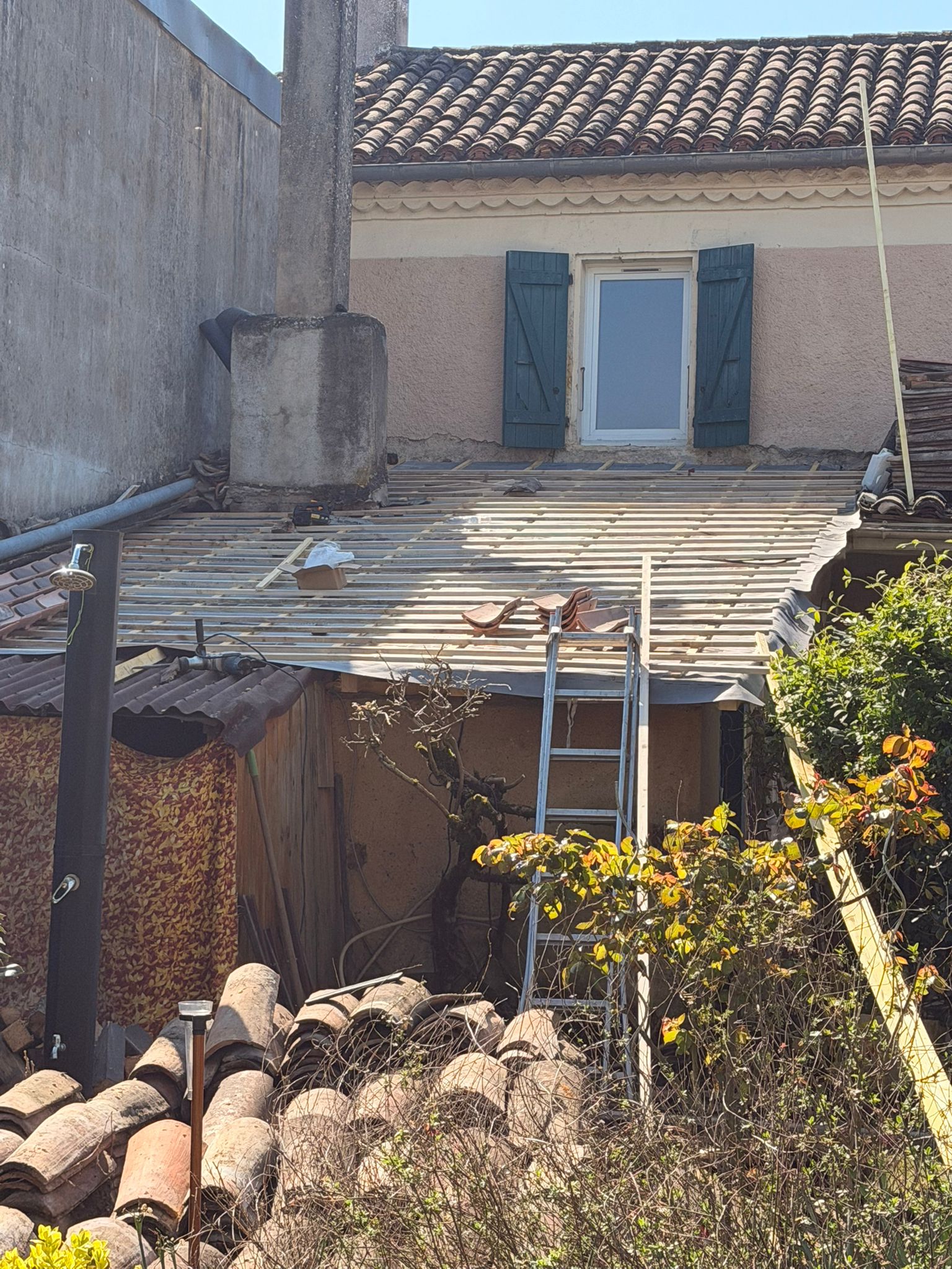 Couvreur posant un velux sur une toiture en ardoise d'une maison à Saint-Girons en Ariège