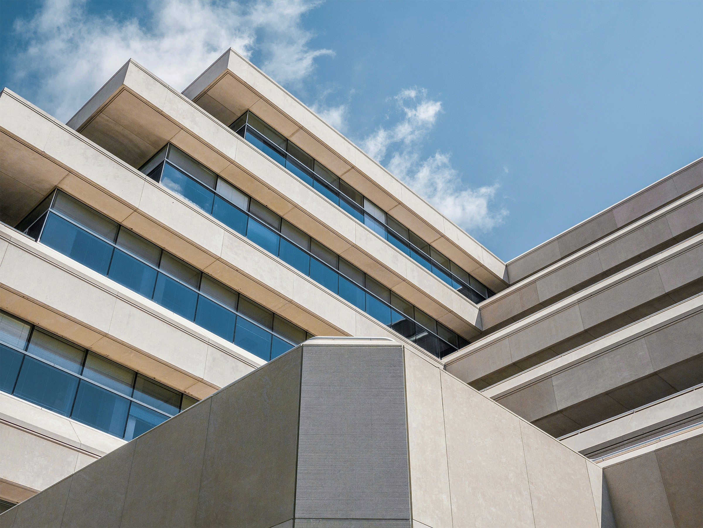 Concrete building with angular architecture and glass panels.