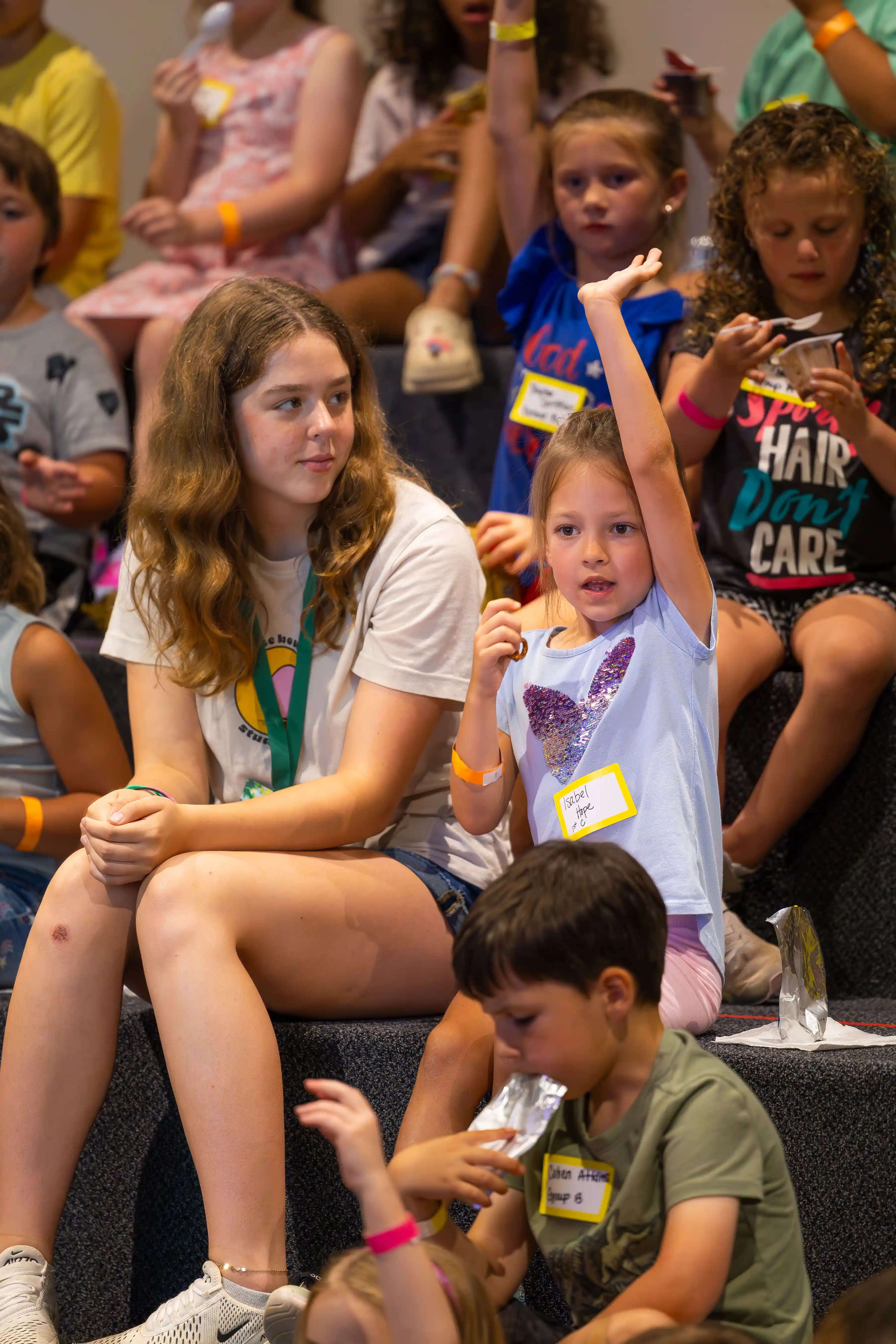 Elementary girl raising hand during Large Group