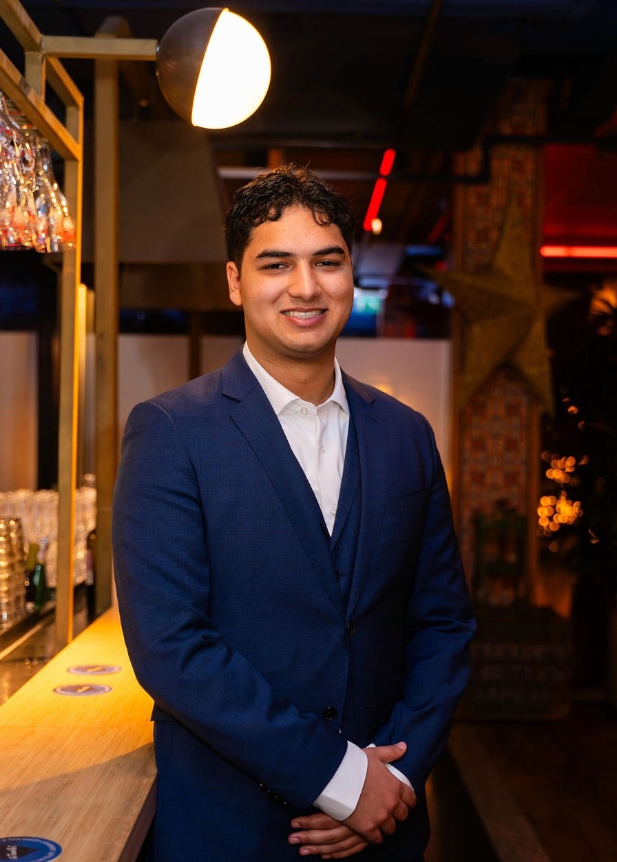 Portrait of a laughing person with curly hair wearing a white shirt