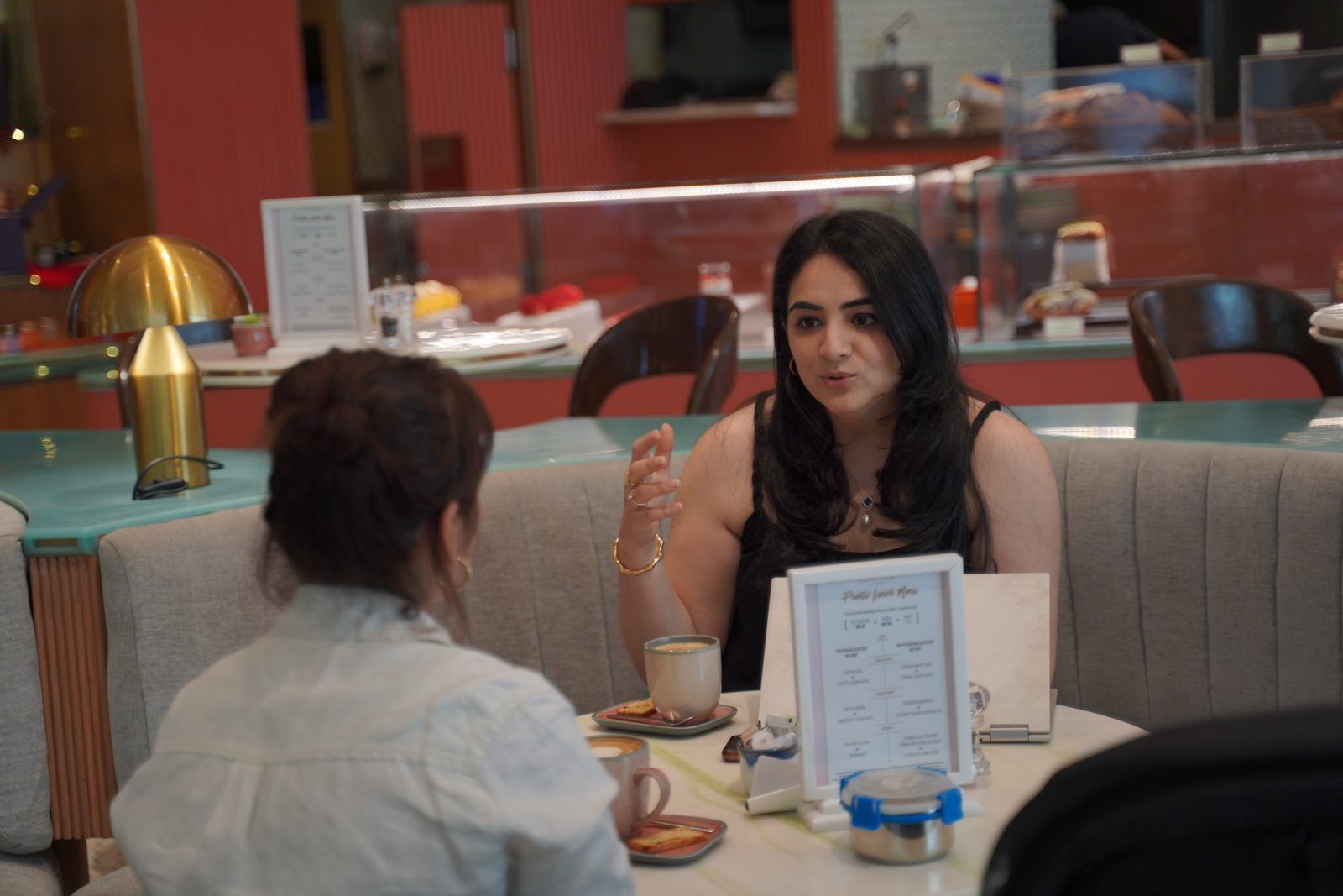Karishma in a coaching conversation with a client over coffee