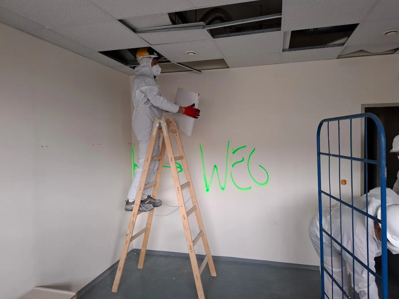 Bagger bei Abbrucharbeiten im Außenbereich beim Rückbau eines Gebäudes mit Staubentwicklung