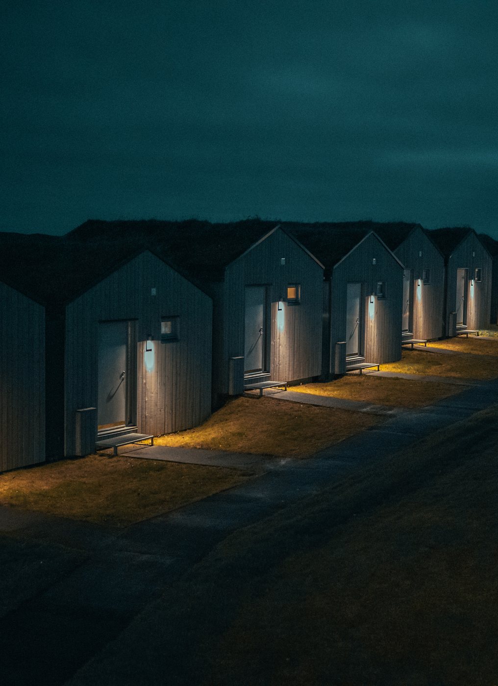 Magma cabins lit up at night beside the lava field