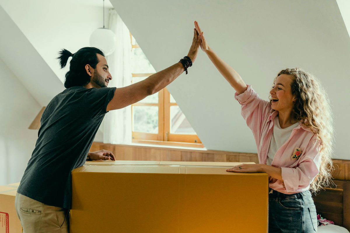 Couple celebrating one more moving box filled.