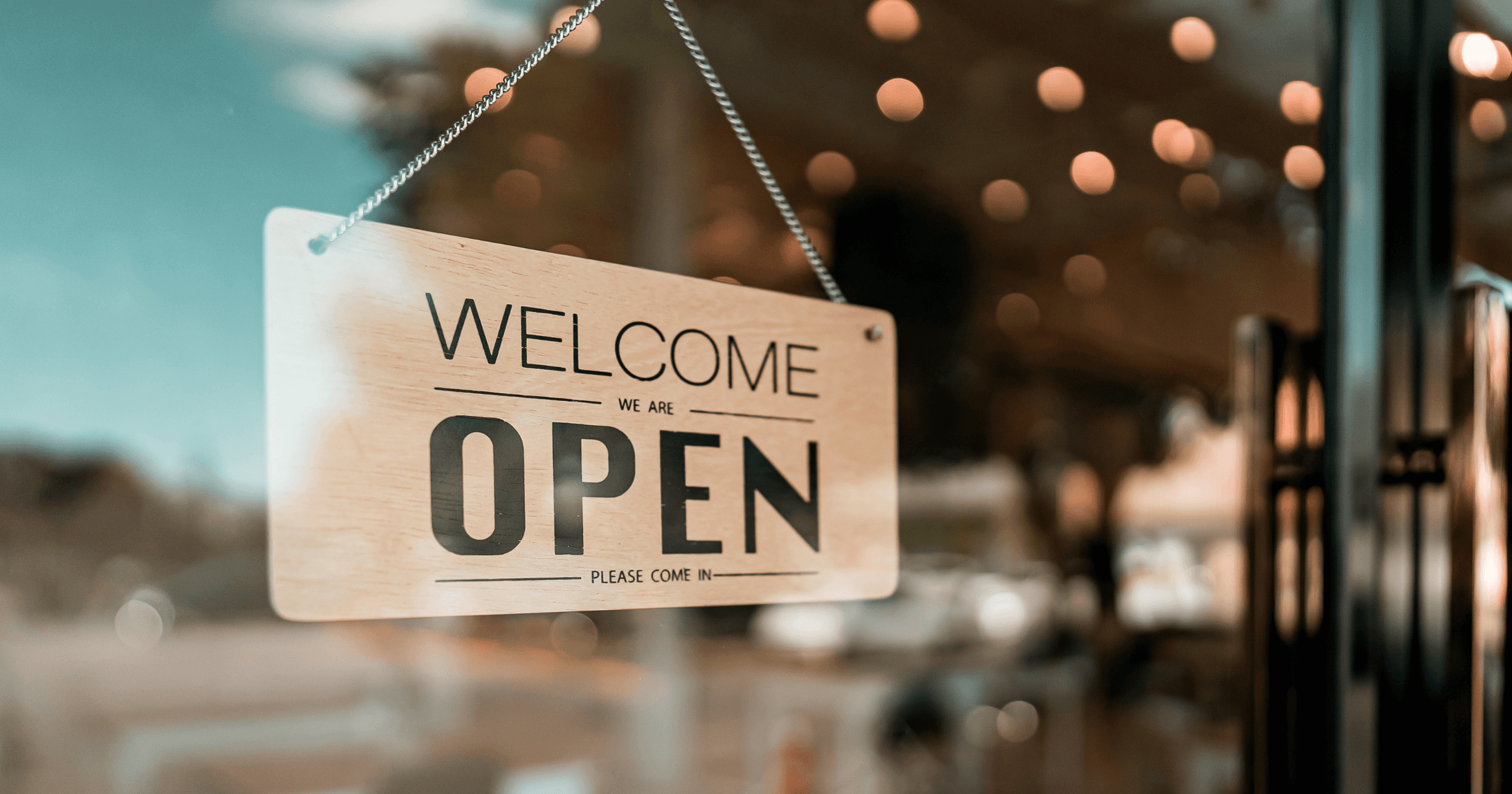 A "Welcome, we are open. Please come in." sign outside an F&B business in Malaysia