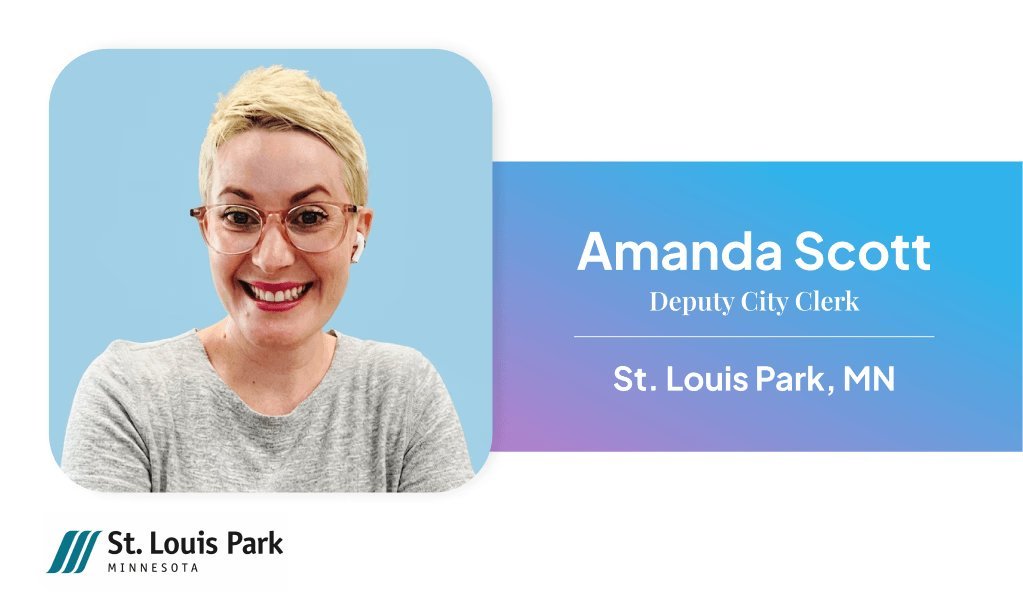 Female municipal clerk seated at office desk with nameplate reading 'Amanda Scott, City of St. Louis Park,' with office décor visible in the background