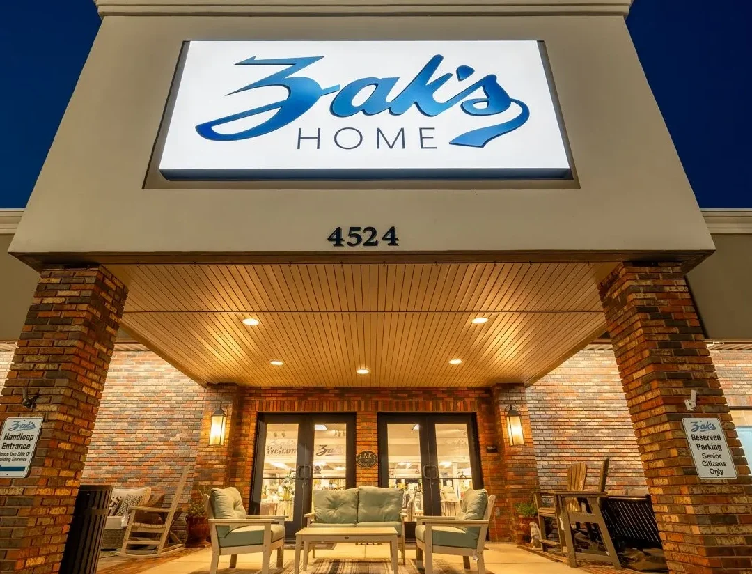 Lit storefront of "Zak's" with a welcoming entrance, showcasing an inviting atmosphere at dusk.