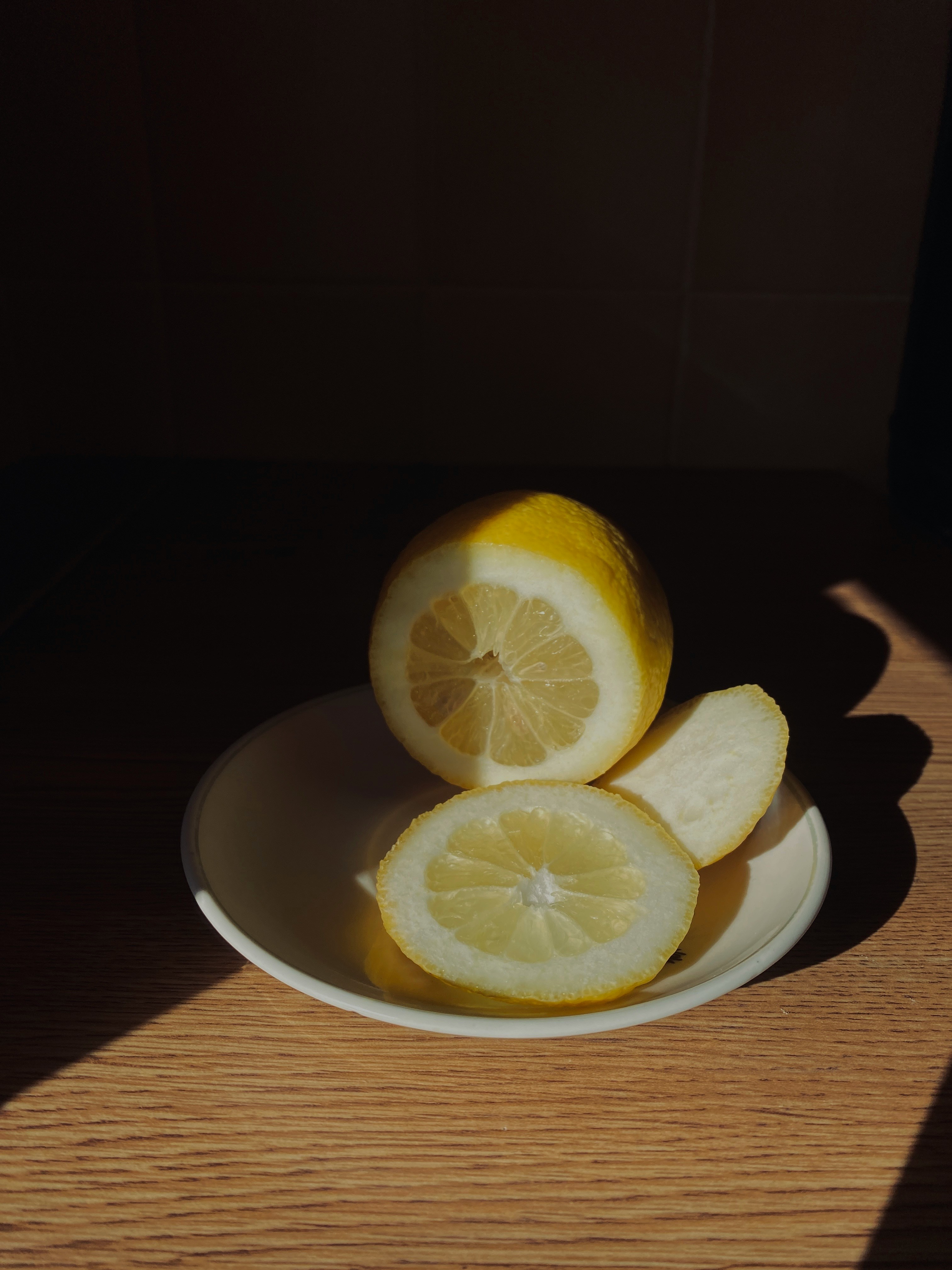 a white plate topped with sliced lemons on top of a wooden table