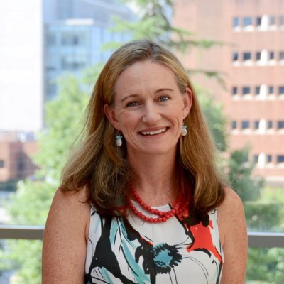 Dr. Erin Ken smiling on balcony in dress