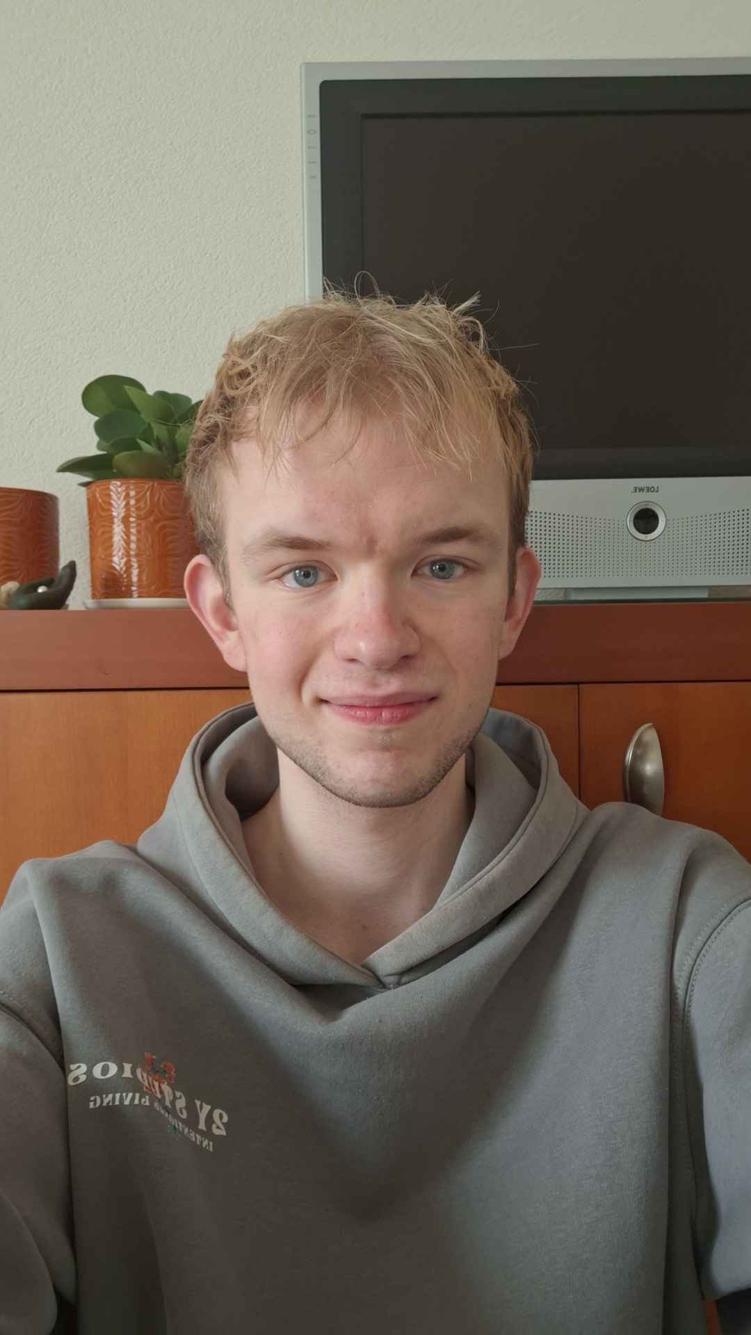 A thoughtful young person with dark hair gazes to the side, captured in soft black and white lighting.