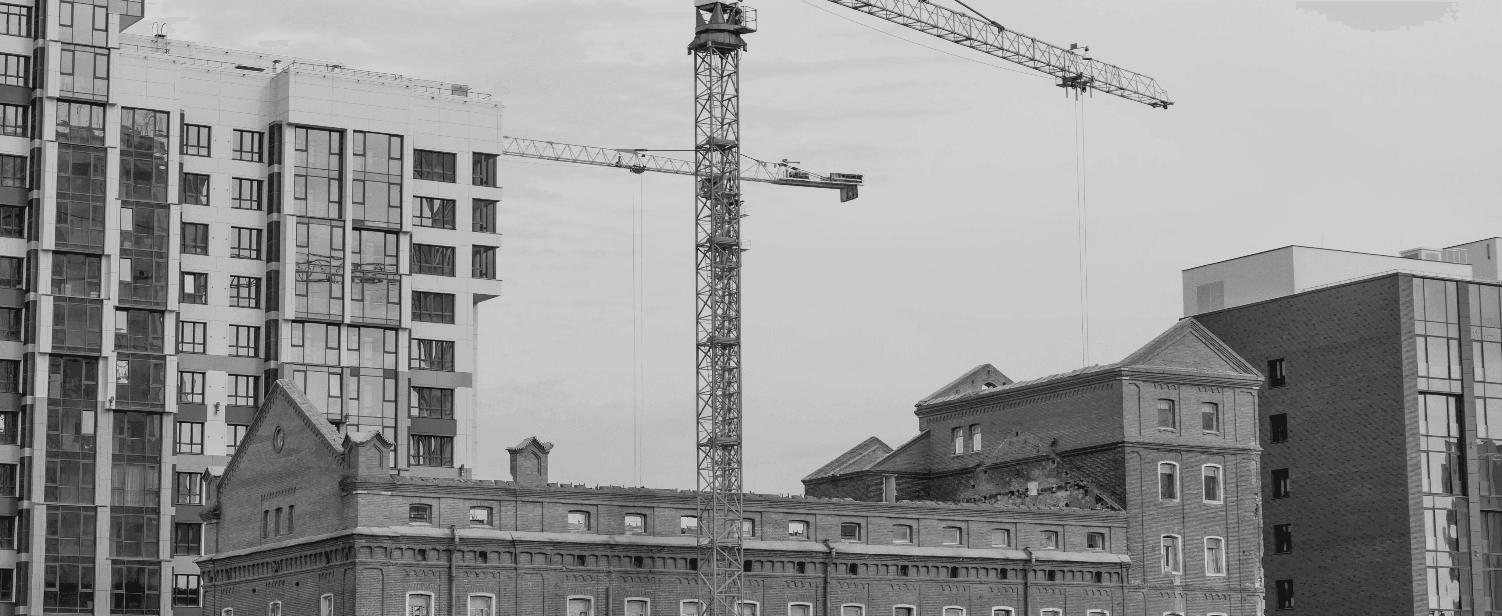 Construction crane and redevelopment site amid city buildings
