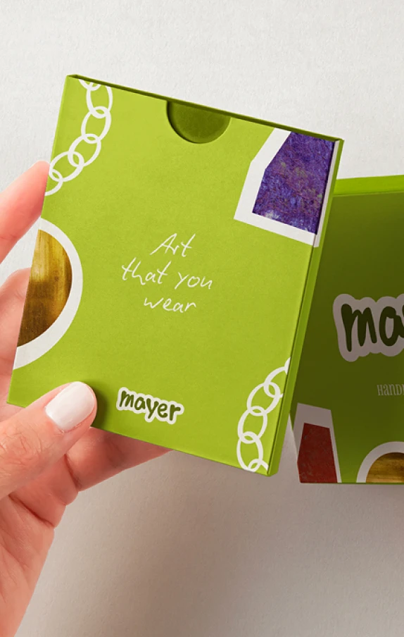 Design packaging pour Mayer Handmade Jewelry par Tartelette Concept : boîte bijou vert anis, découpes collage arty et slogan "Art that you wear".