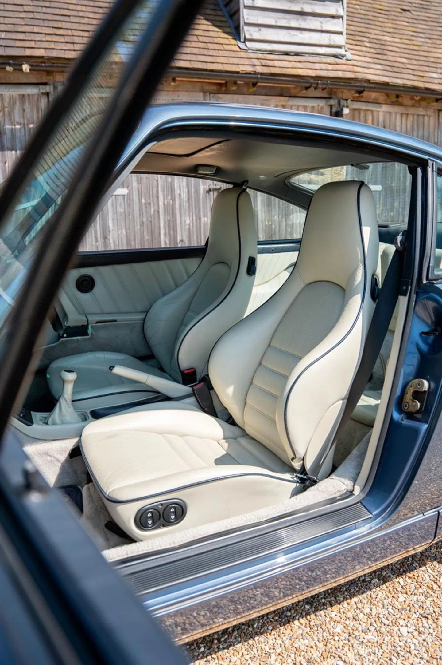 White leather sport seats with blue piping viewed through the door