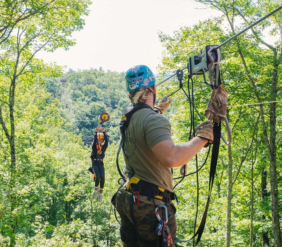 A guide safely guides a zipliner into the recieving area