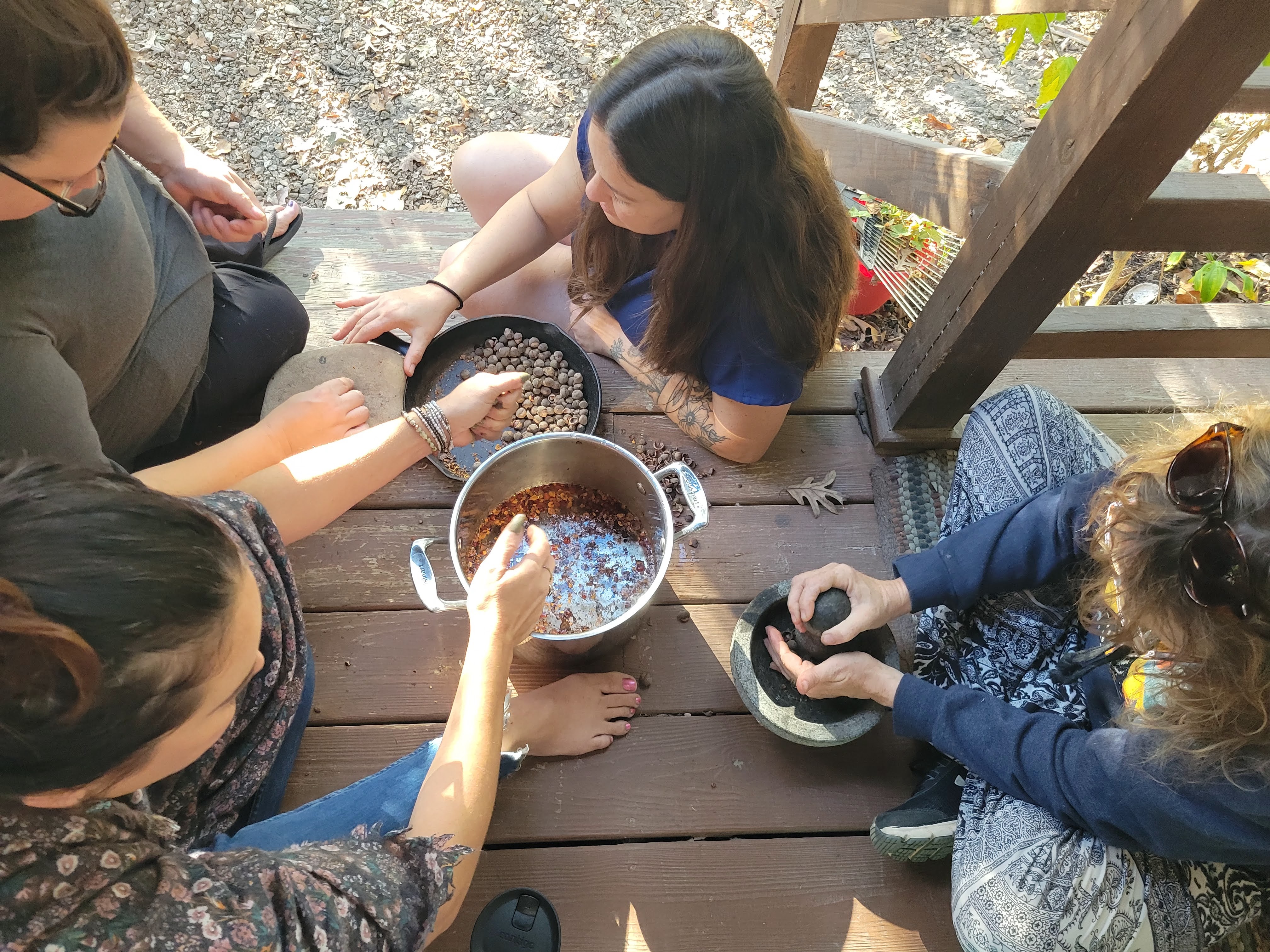 Group of students processing acorns together during a foraging class, representing shared learning and scholarship.