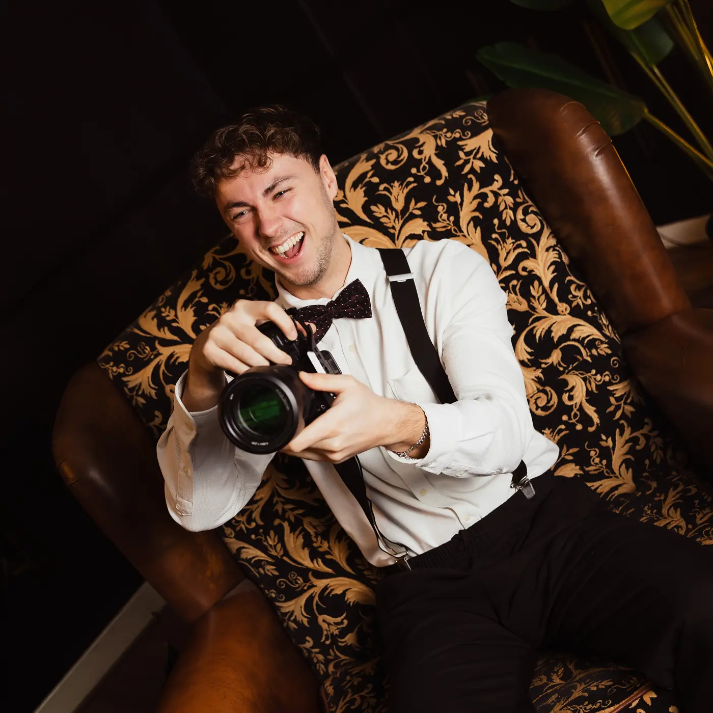 A red hot air balloon glows at sunset over mountains.