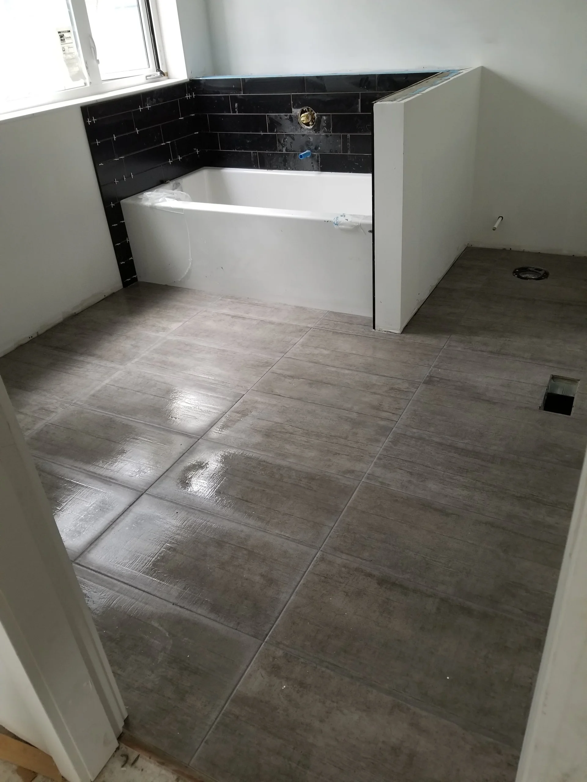 Modern two-story home with large glass windows, warmly lit interiors, and a balcony. Surrounded by trees and a manicured lawn at dusk. Cozy ambiance.