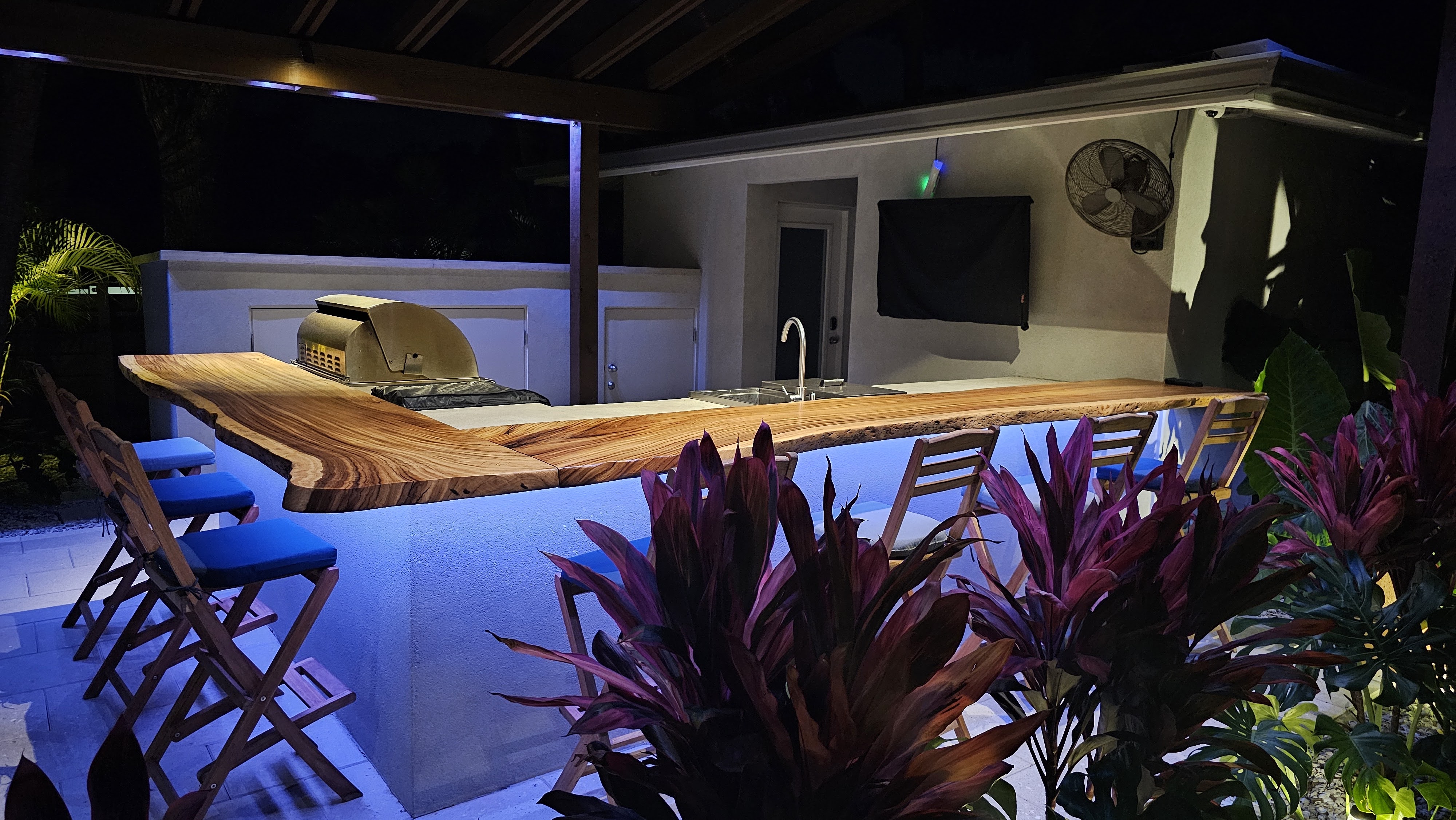 Custom outdoor kitchen and bar lighting integrated into a covered patio design