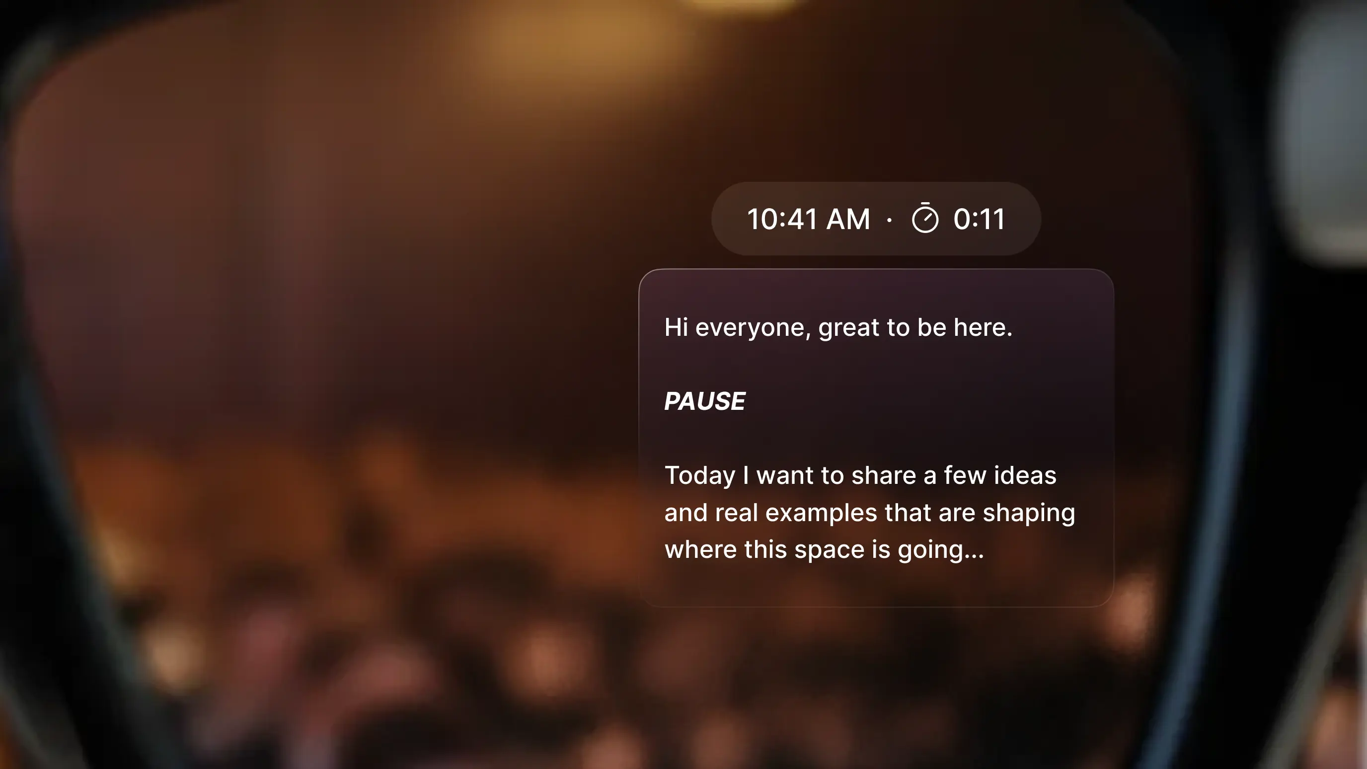 Point-of-view shot through smart glasses showing a teleprompter overlay in the wearer's field of view. The display reads: "Hi everyone, great to be here. PAUSE. Today I want to share a few ideas and real examples that are shaping where this space is going..." A timer reads 0:11 and the time shows 10:41 AM.