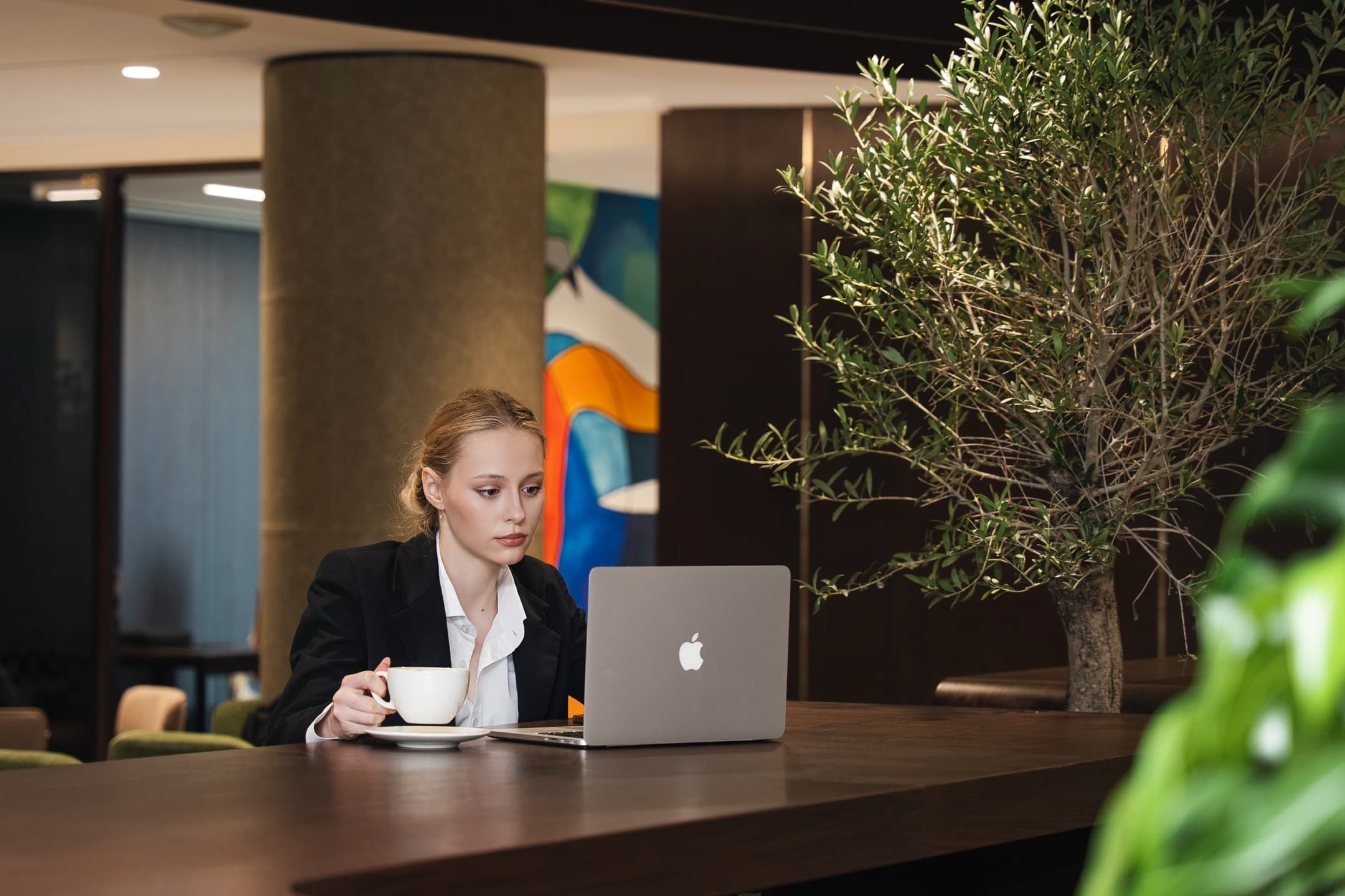 Premium meeting room in Dubai featuring a wood-paneled wall, high-definition screen, and an 8-seater conference table.