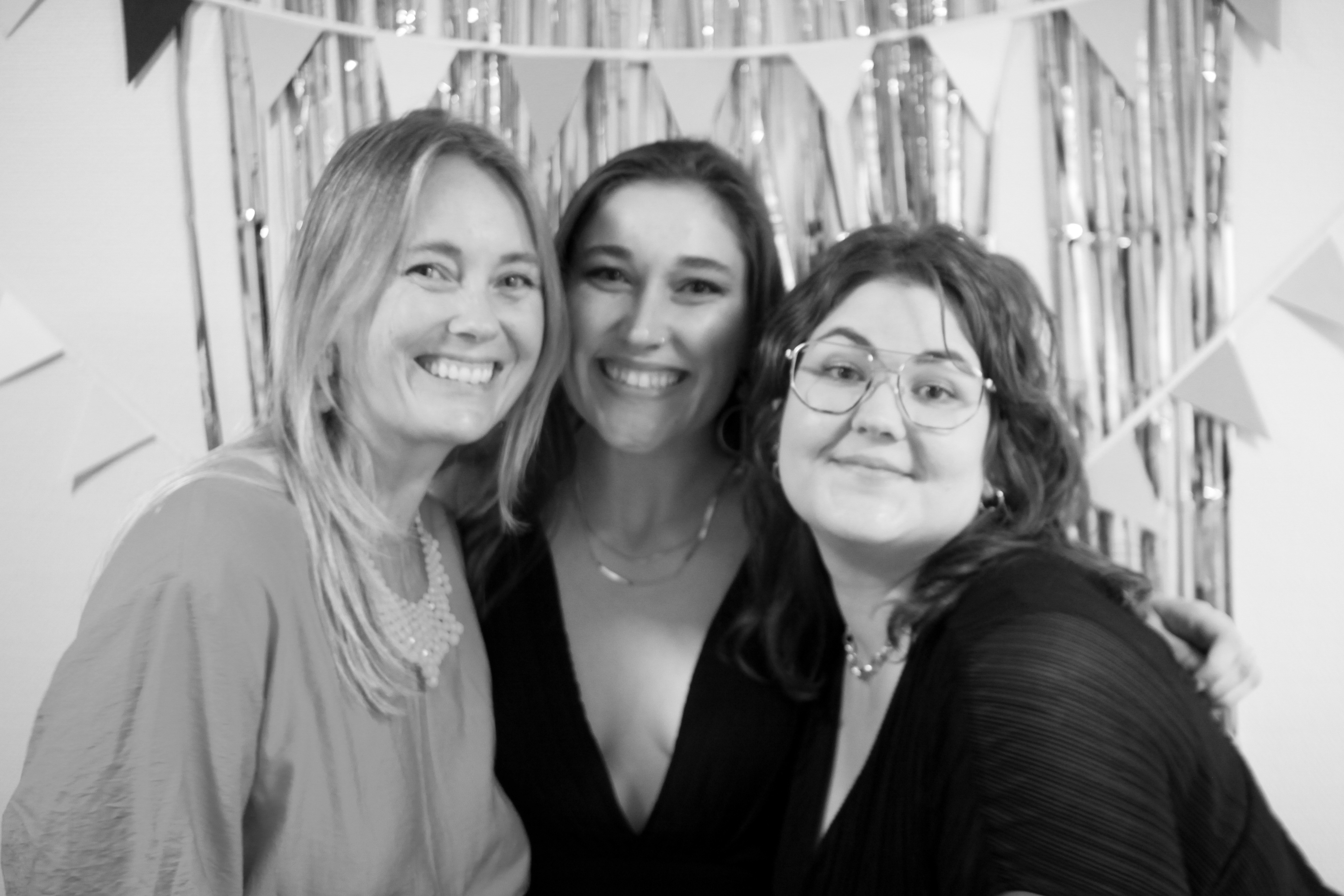 Three people smiling in front of the camera.