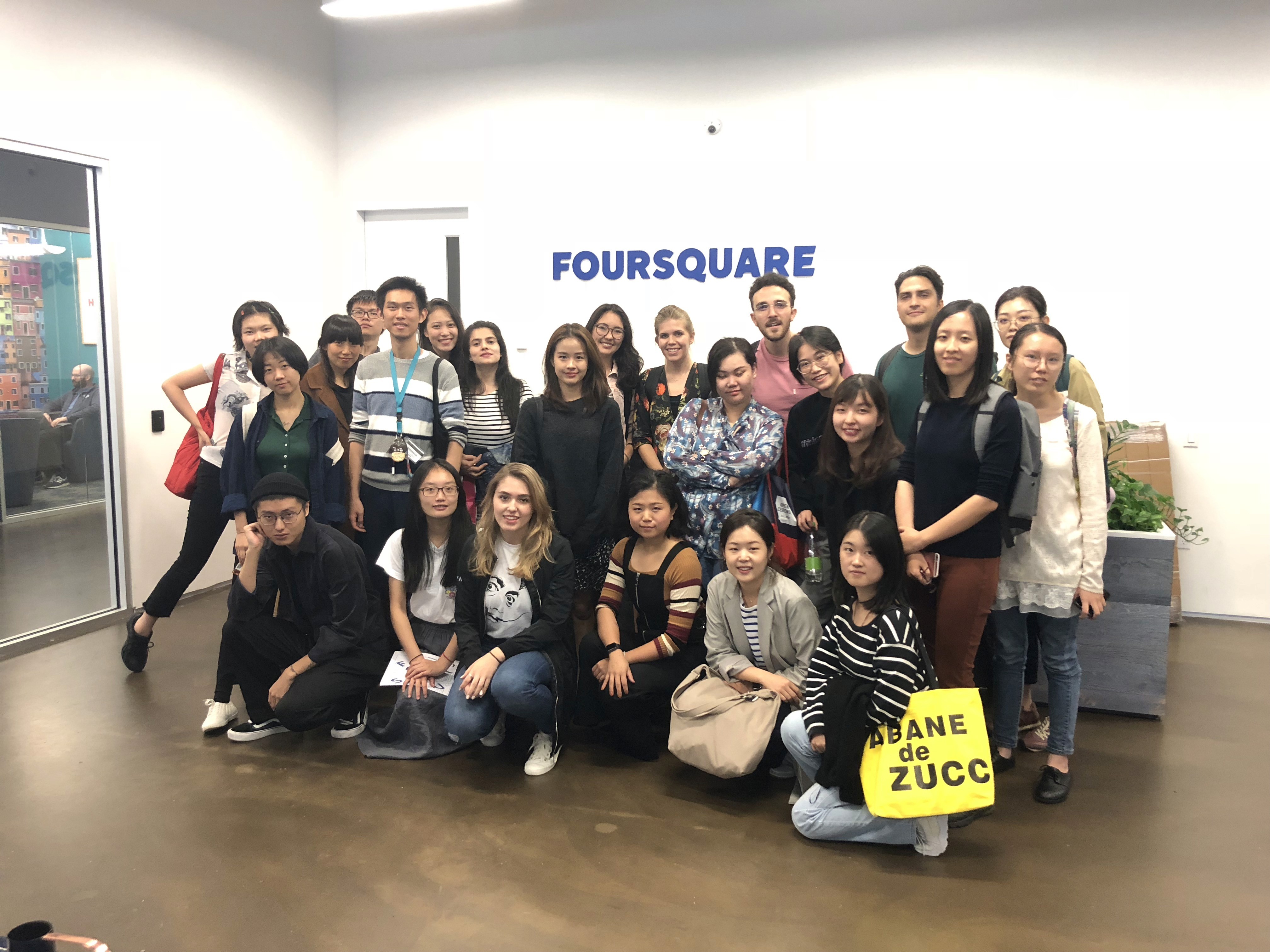 A group photo in an office and behind them, on a wall, the word Foursquare is visible.