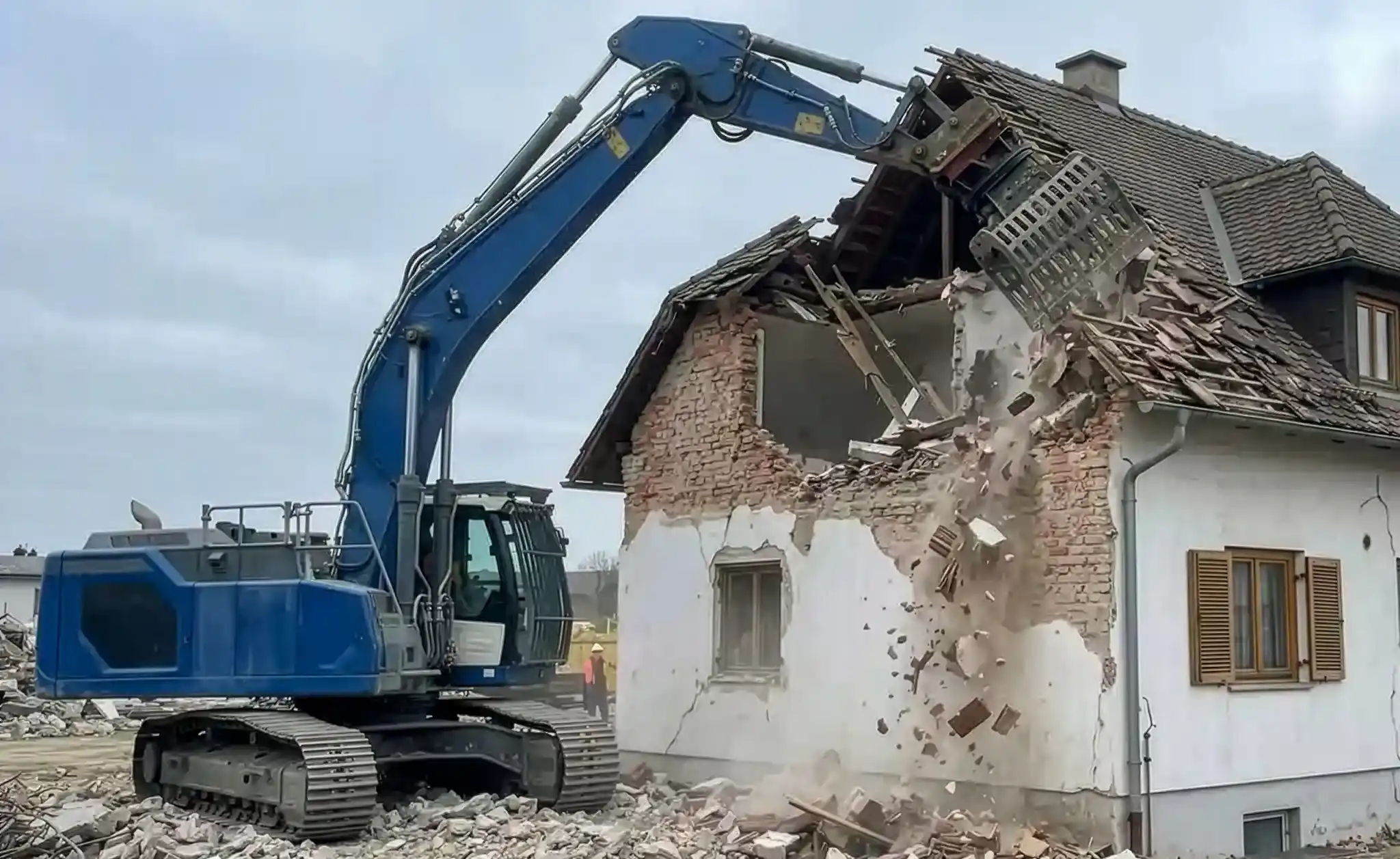 Bagger bei Abbrucharbeiten im Außenbereich beim Rückbau eines Wohngebäudes